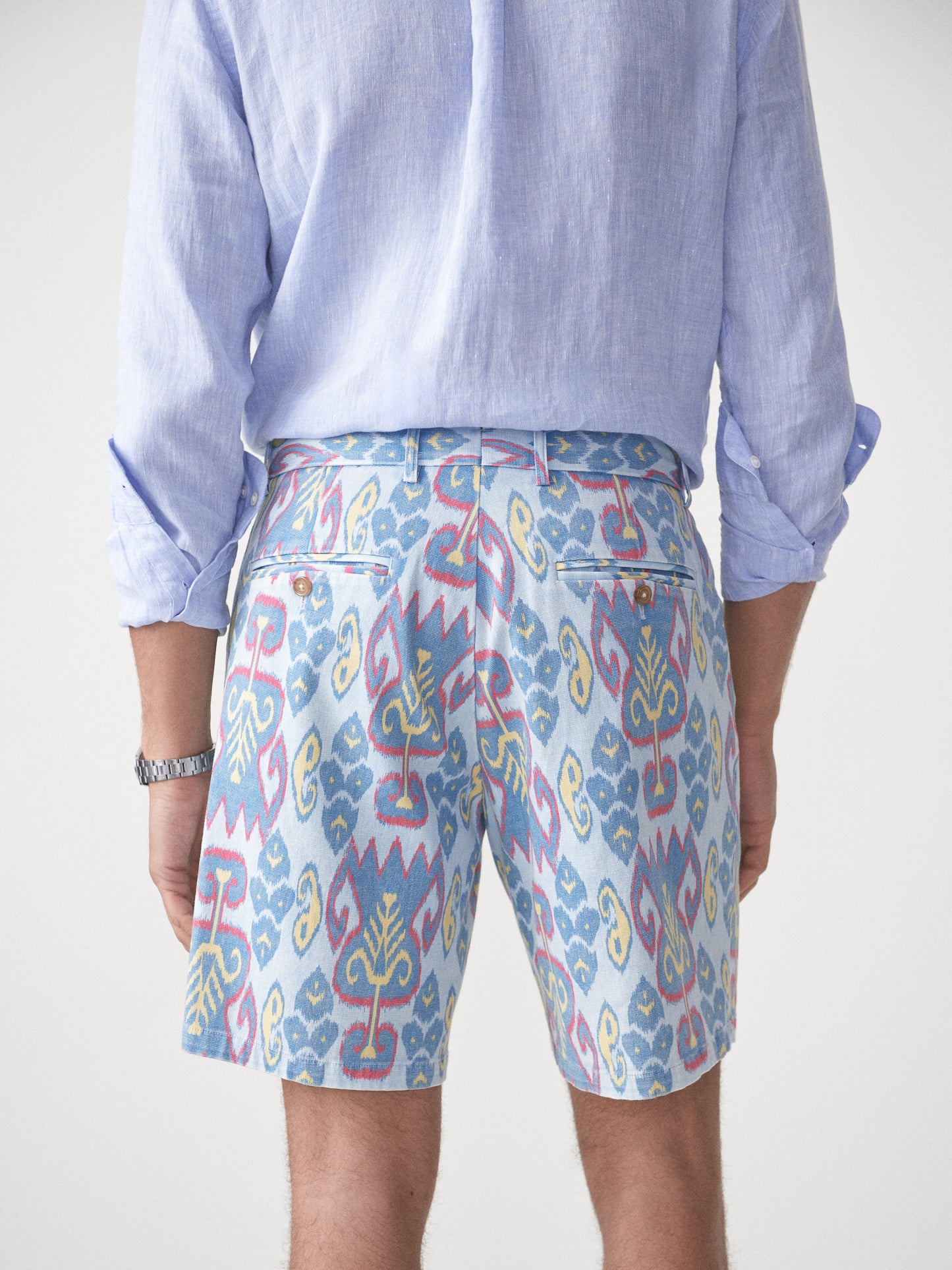 Model wearing J.McLaughlin Oliver shorts in aqua/blue/gold made with cotton.