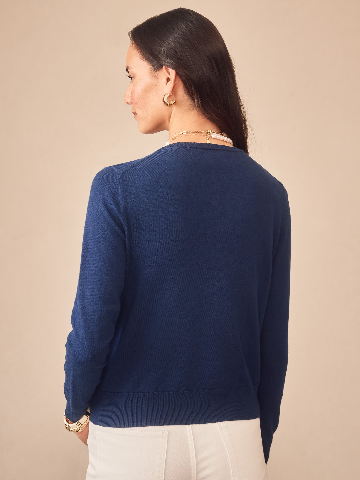 Woman wearing a navy blue Pearl Cardigan by J.McLaughlin, featuring an effortlessly stylish design with enduring craftsmanship, embodying the legacy of timeless fashion at A destination for defining style. Life, Well-Lived.
