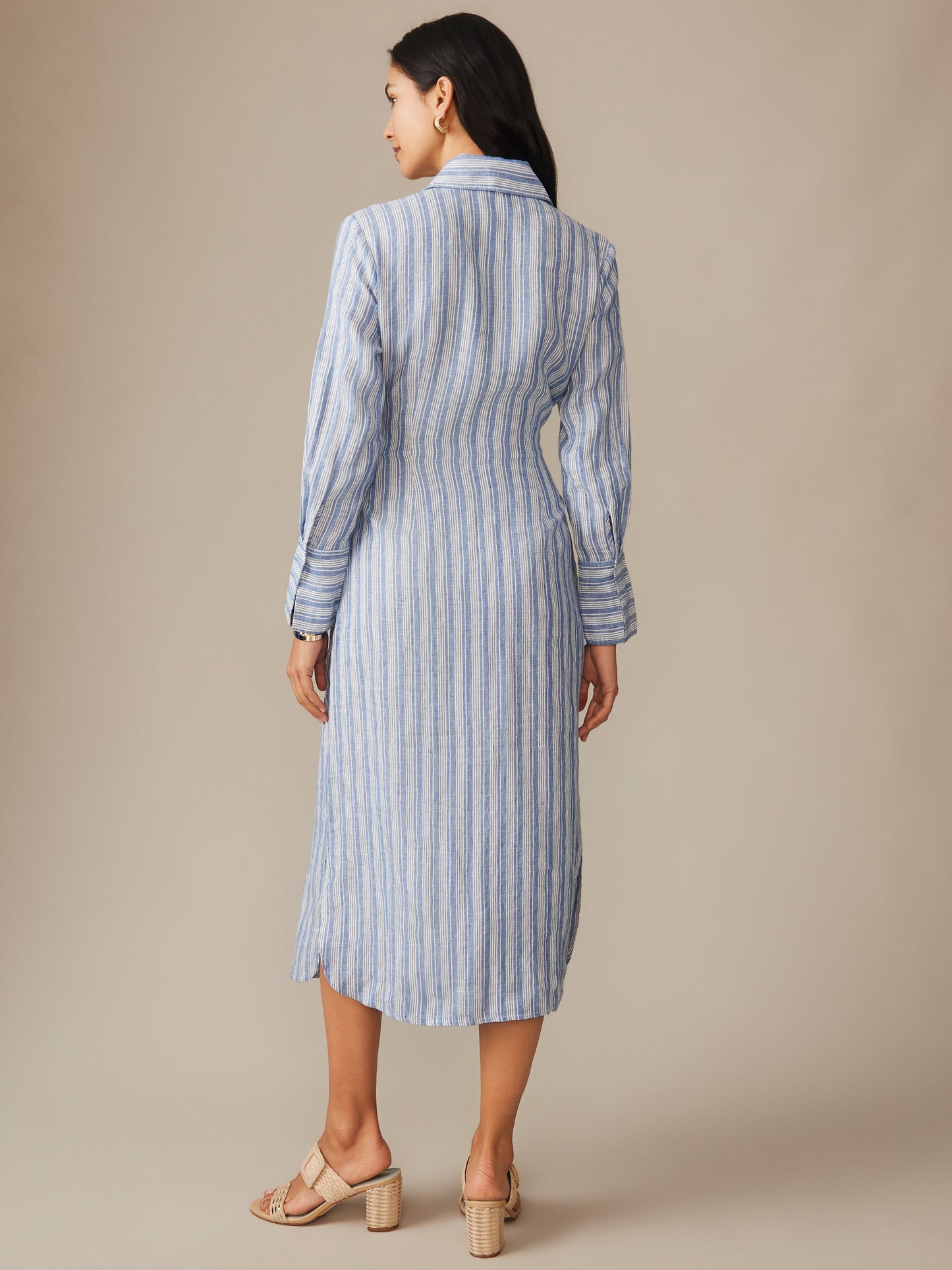 Woman wearing the Orla Linen Dress in Stripe by J.McLaughlin, featuring lightweight linen fabric with blue and white stripes, showcasing effortlessly stylish, enduring designs.