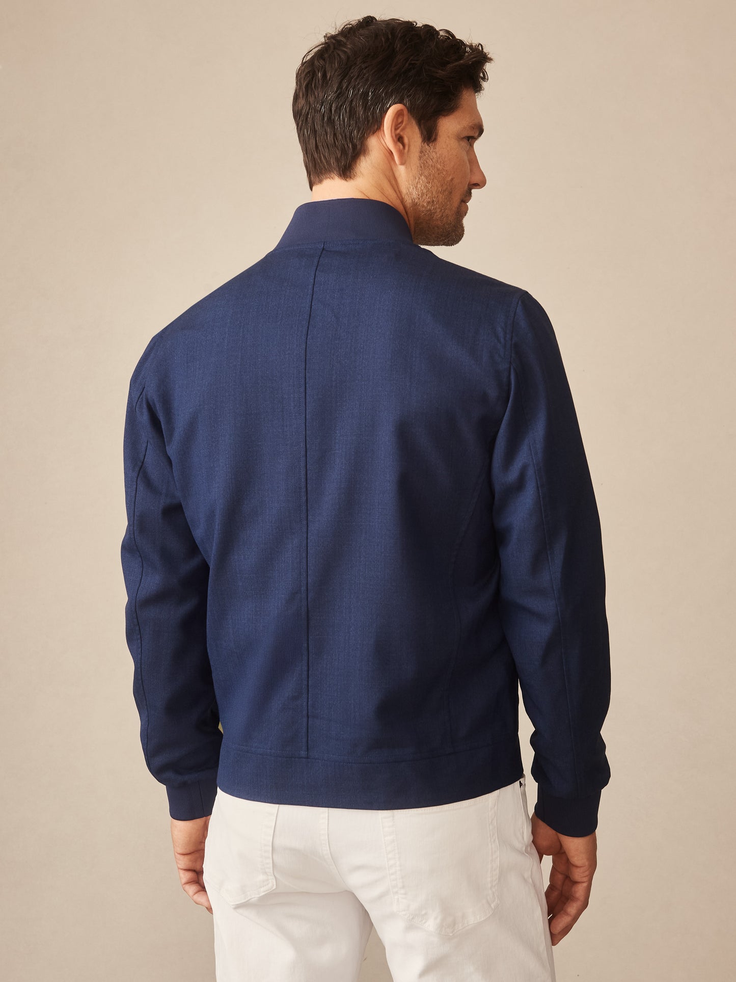 Man wearing a navy Outfield Jacket by J.McLaughlin, showcasing effortlessly stylish, enduring designs with innovative fabrics for a legacy of timeless fashion.