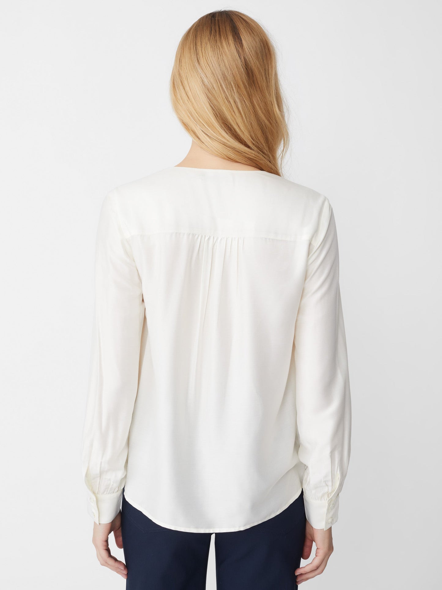 Model wears J.McLaughlin Rinaldo blouse in off white made with silk/rayon.