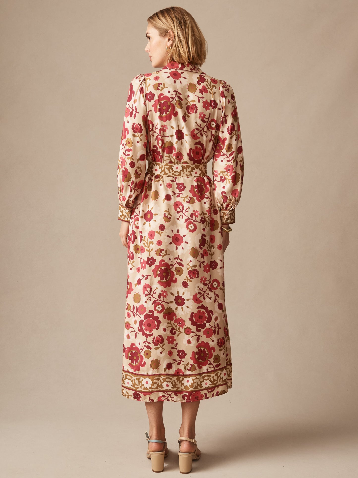 Woman wearing the Serena Silk Blend Dress in Floral Daydream Frame by J.McLaughlin, featuring a beige base with red floral pattern, long sleeves, and a midi length, embodying effortlessly stylish, enduring designs with innovative fabrics and a legacy of timeless fashion. A destination for defining style. Life, Well-Lived.