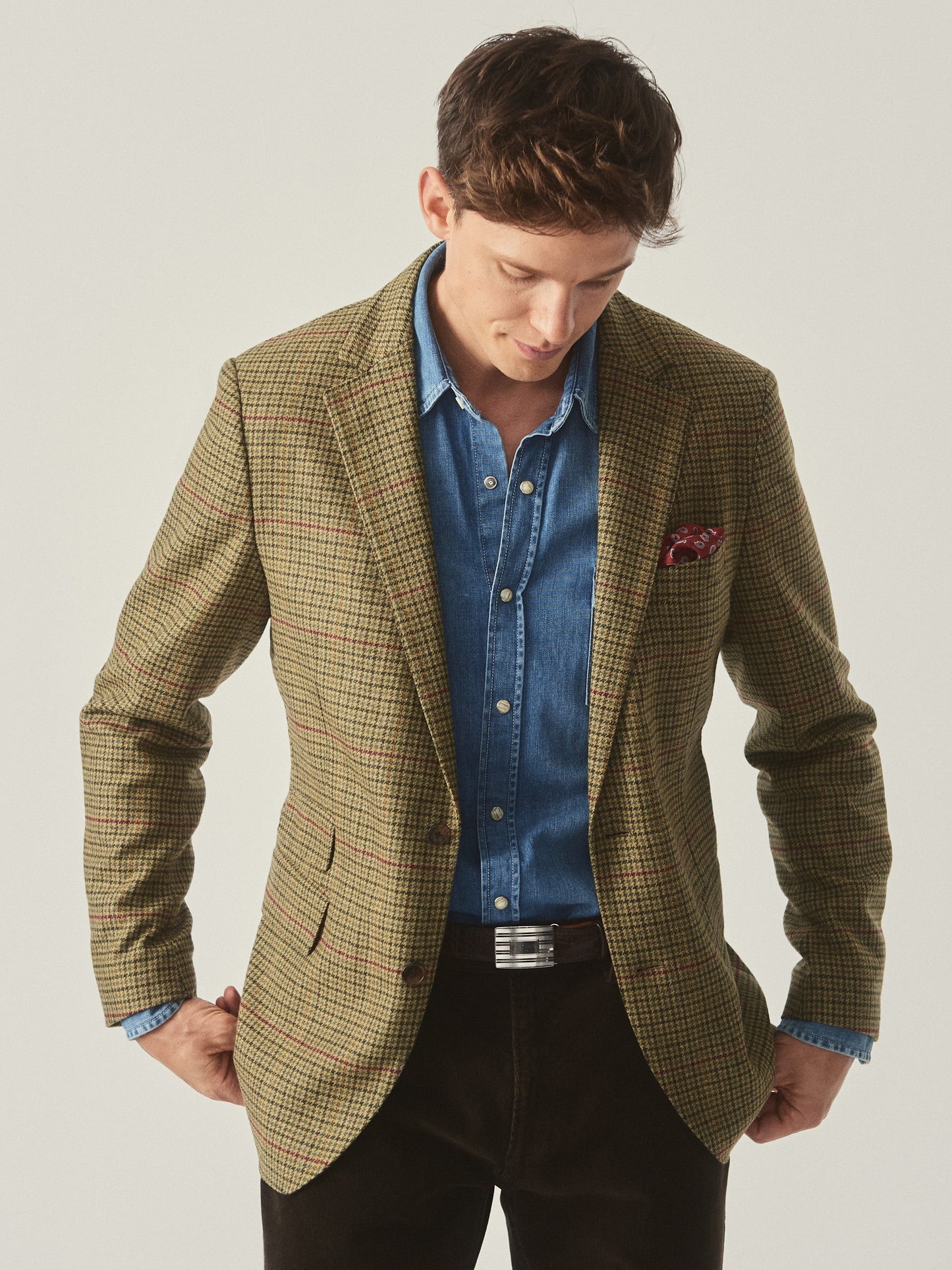 Model wearing J.McLaughlin Suffolk blazer in brown/green/red/mustard made with wool.