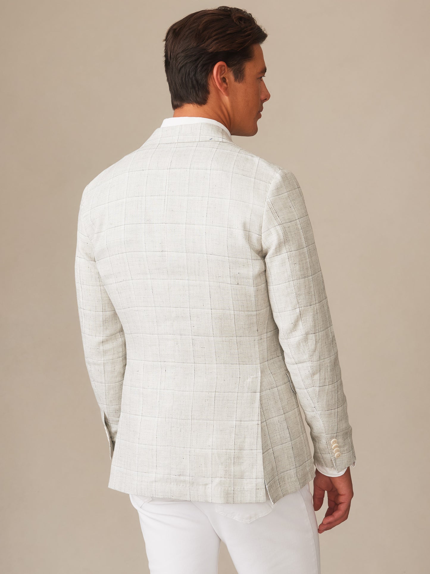 A man wearing the Suffolk Linen Sport Coat in Window Pane by J.McLaughlin, showcasing effortlessly stylish and enduring designs crafted with innovative fabrics, embodying a legacy of timeless fashion. A destination for defining style. Life, Well-Lived.