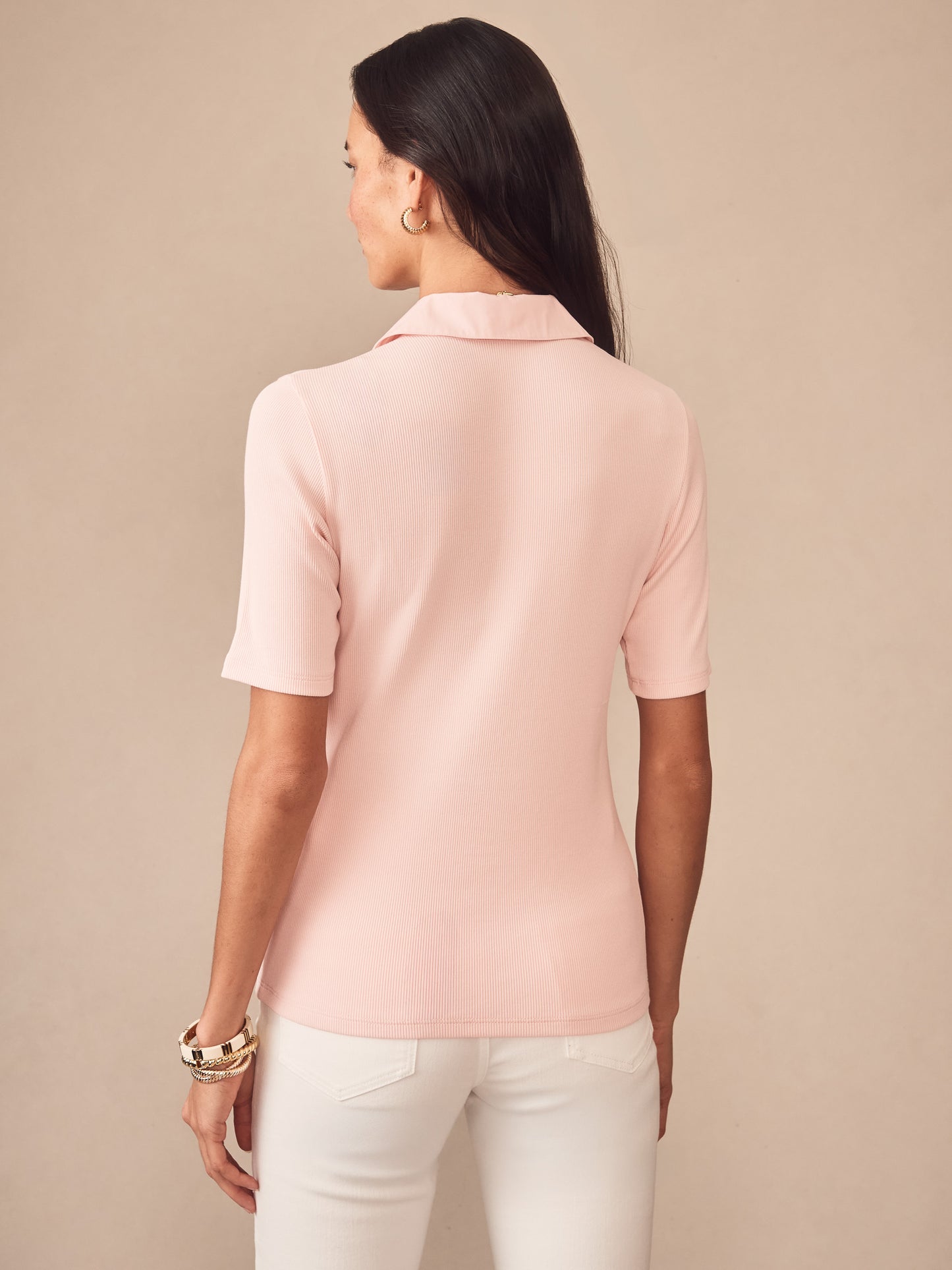 A woman wearing the Theodora Short Sleeve Shirt in soft blush pink by J.McLaughlin, showcasing effortlessly stylish, enduring designs crafted from innovative fabrics for a legacy of timeless fashion.