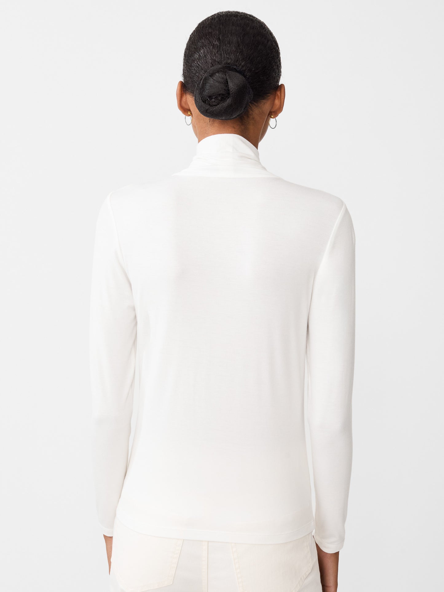 Model wearing J.McLaughlin Nadia turtleneck in off white made with rayon/spandex.