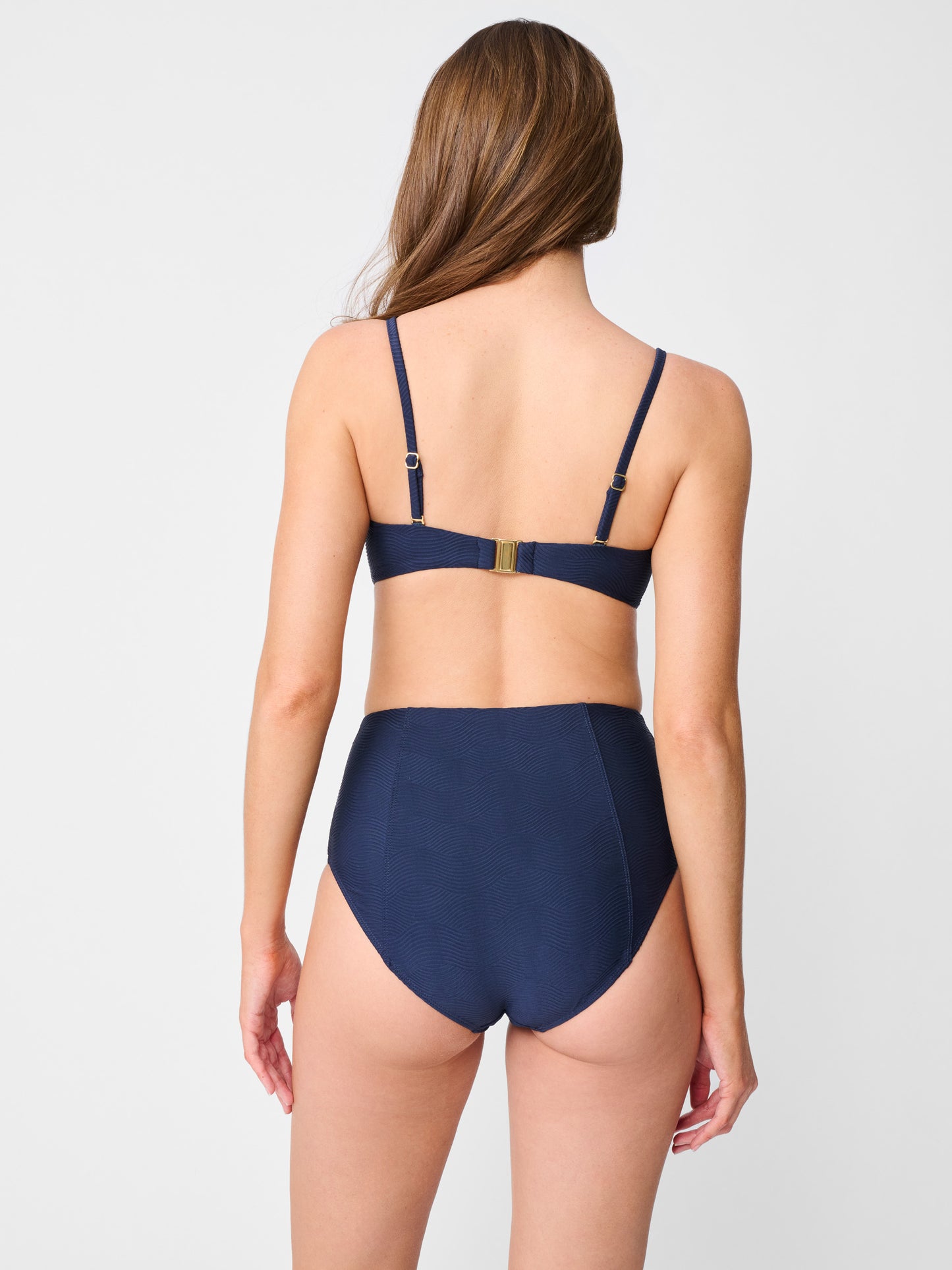Model wearing J.McLaughlin Wailea bikini top in navy made with nylon and lycra.