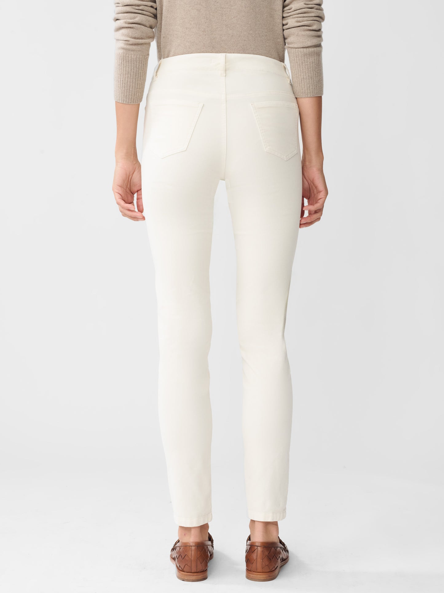 Model wearing J.McLaughlin Watson jeans in egret white made with velveteen.