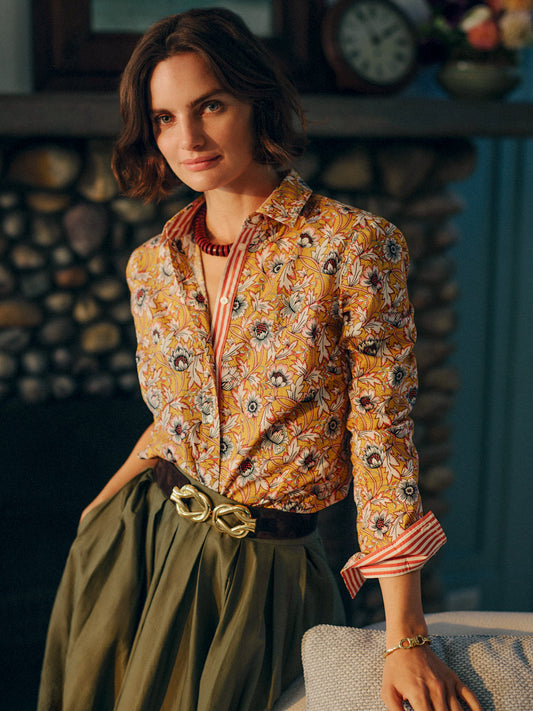 Woman wearing the Lois Shirt in Belle Epoque Bloom Stripe by J.McLaughlin, styled with a green skirt and gold buckle belt, showcasing enduring designs and impeccable craftsmanship.