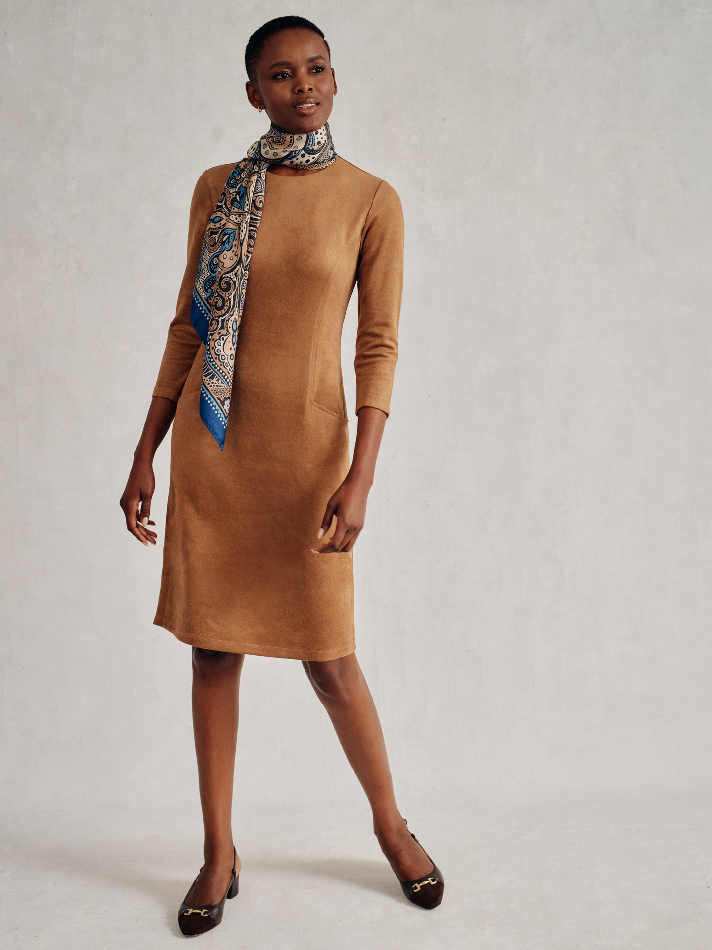 Model wearing J.McLaughlin Catalyst dress in tan made with faux suede.