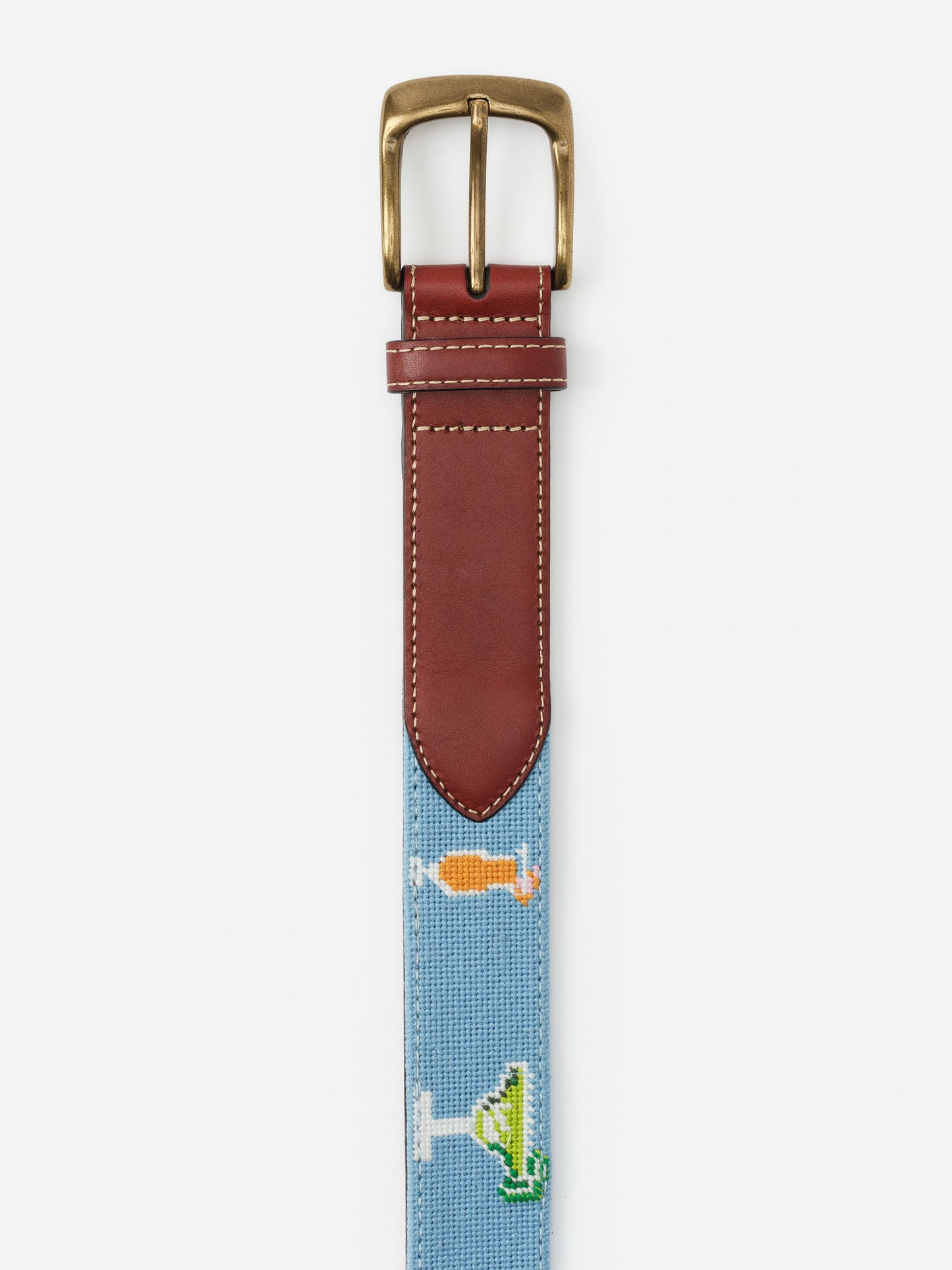 Needlepoint Belt in Cocktail Party by J.McLaughlin features a blue fabric strap with embroidered cocktail designs and brown leather trim, showcasing effortlessly stylish, enduring designs.