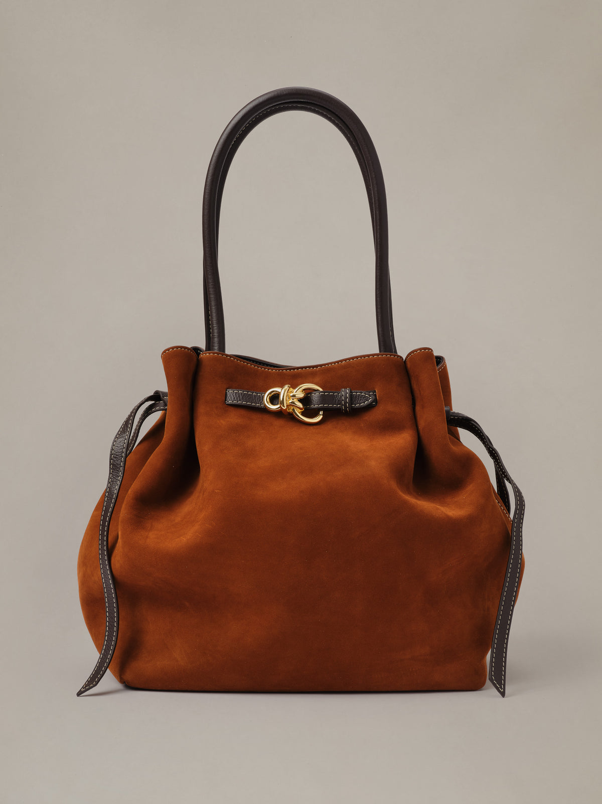 The Lex Suede Tote Bag by J.McLaughlin in rich brown suede with long handles, drawstring sides, and polished gold hardware for timeless everyday style