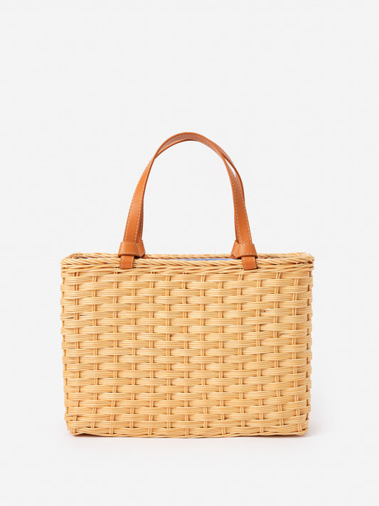 Caroline Wicker Handbag by J.McLaughlin features an effortlessly stylish woven wicker design with leather handles, blending enduring designs and innovative fabrics for a timeless accessory.