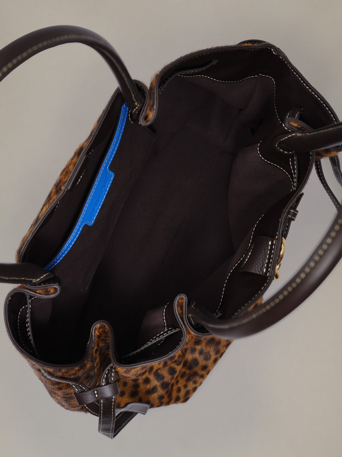 The Lex Pony Hair Tote Bag in Leopard by J.McLaughlin open showing a spacious dark interior and leather handles