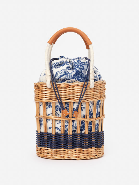 Caryl Wicker Handbag in Giardino Toile from J.McLaughlin, featuring woven wicker with navy and white toile fabric, effortlessly stylish for enduring designs and timeless fashion.