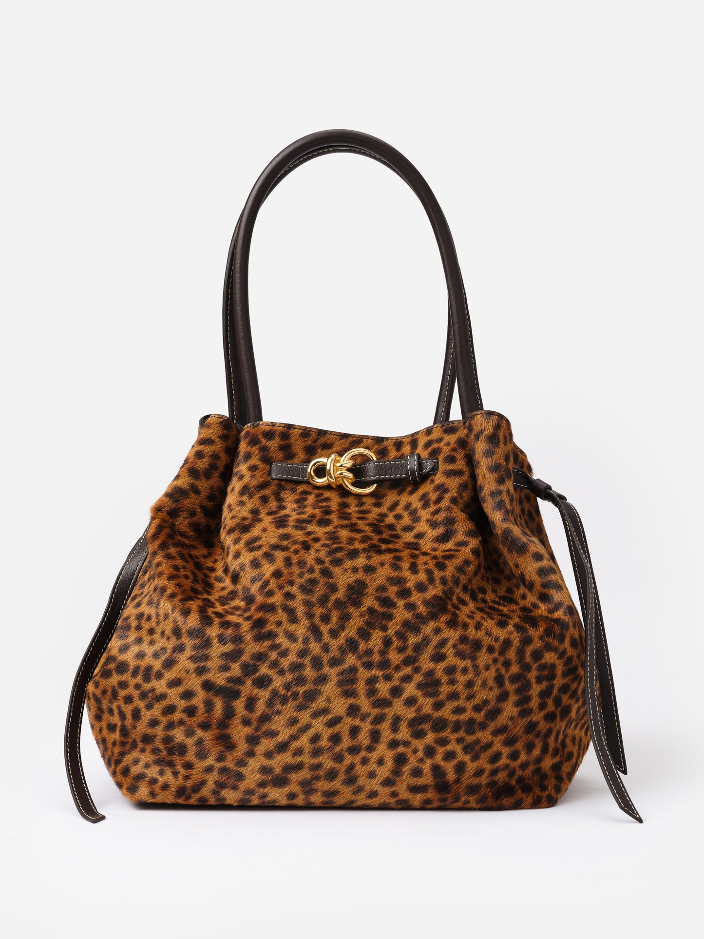 The Lex Pony Hair Tote Bag in Leopard by J.McLaughlin features a spacious, stylish leopard print design with leather handles and a gold-tone clasp, embodying timeless fashion.