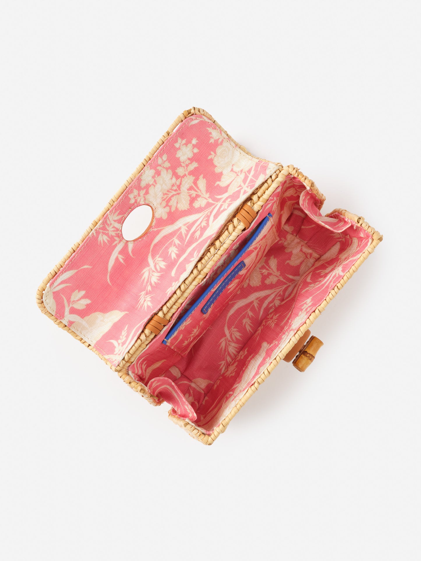 Waverly Wicker Handbag by J.McLaughlin, featuring a timeless wicker exterior and a vibrant pink floral fabric interior, embodying effortlessly stylish, enduring designs for life well-lived.