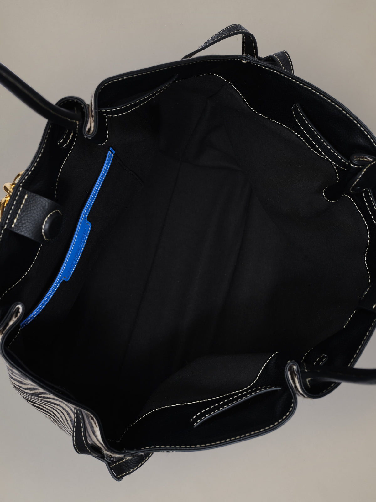 The Lex Pony Hair Tote Bag in Zebra Stripes by J.McLaughlin showing its spacious black lined interior and practical pockets