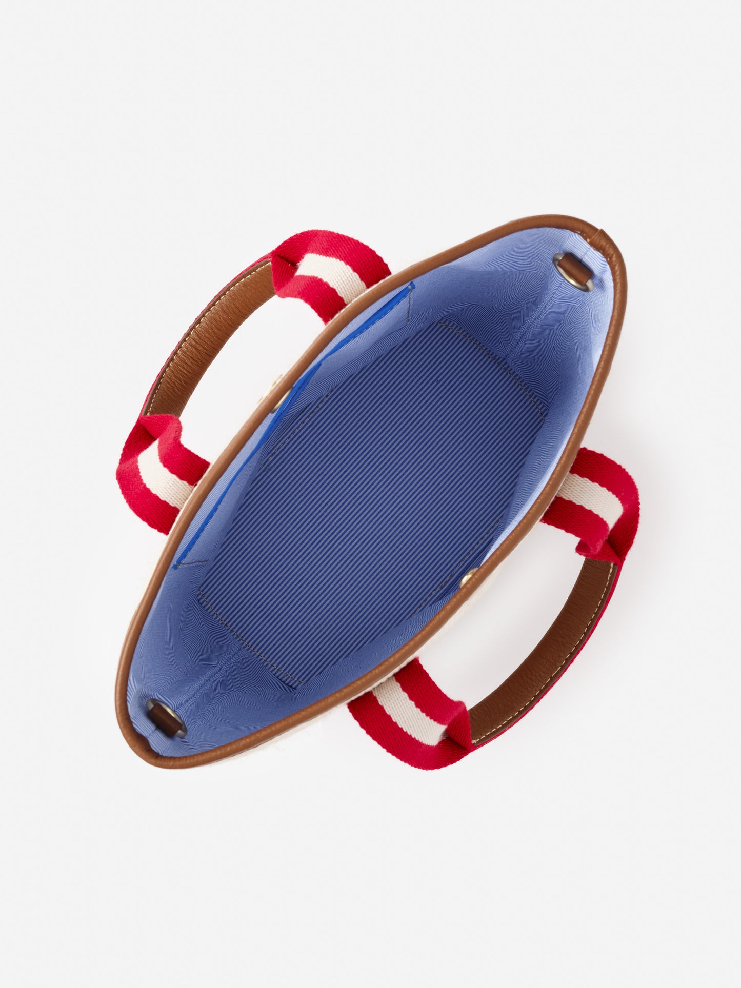Interior view of the Emery Canvas Mini Tote by J.McLaughlin showing blue lining and red and white striped handles, reflecting effortlessly stylish, enduring designs with innovative fabrics in a legacy of timeless fashion. A destination for defining style. Life, Well-Lived.