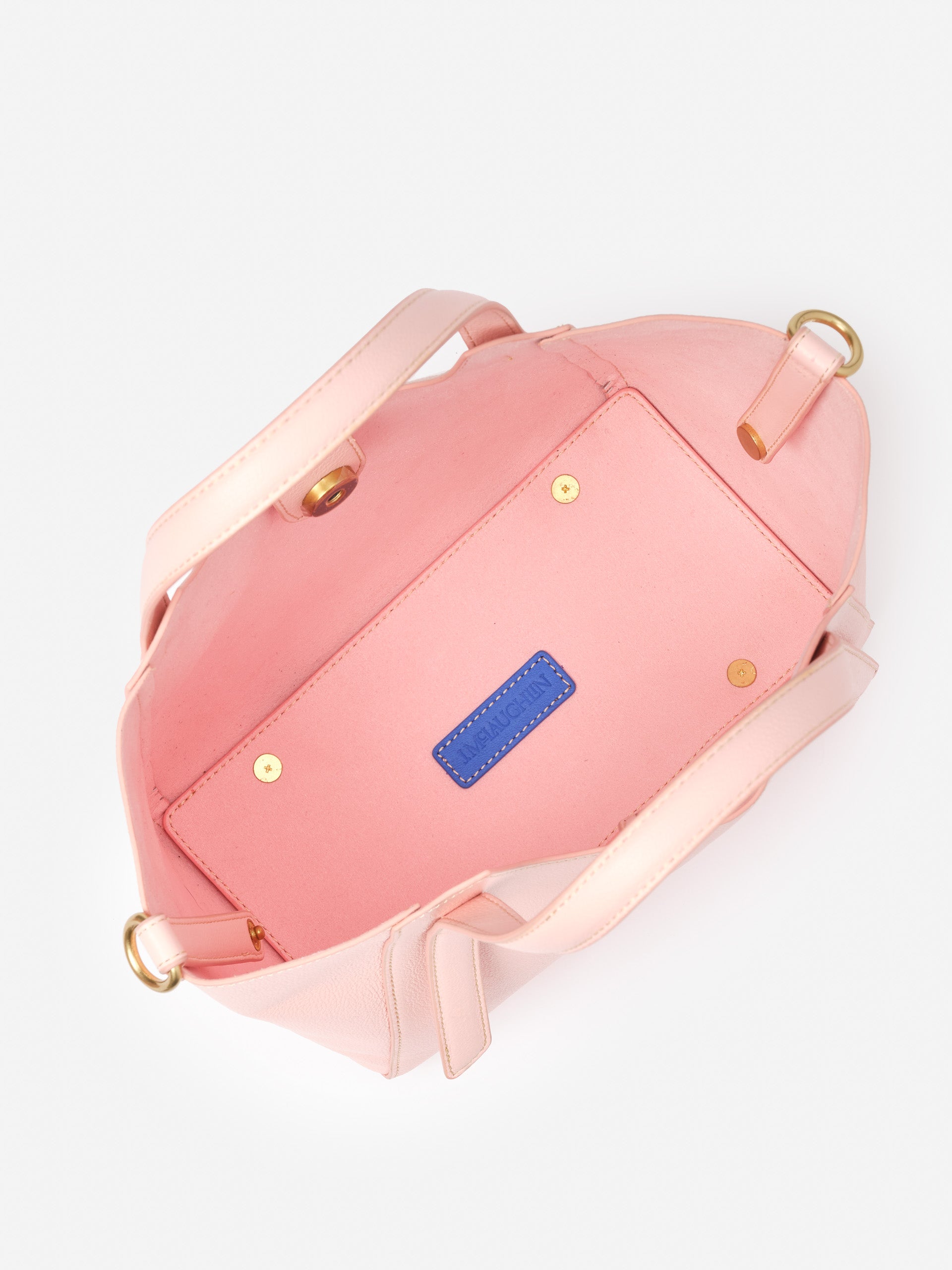 Interior view of a pink Lane Leather Mini Tote by J.McLaughlin, showcasing impeccable craftsmanship and durable detailing, epitomizing effortlessly stylish, enduring designs for life well-lived.