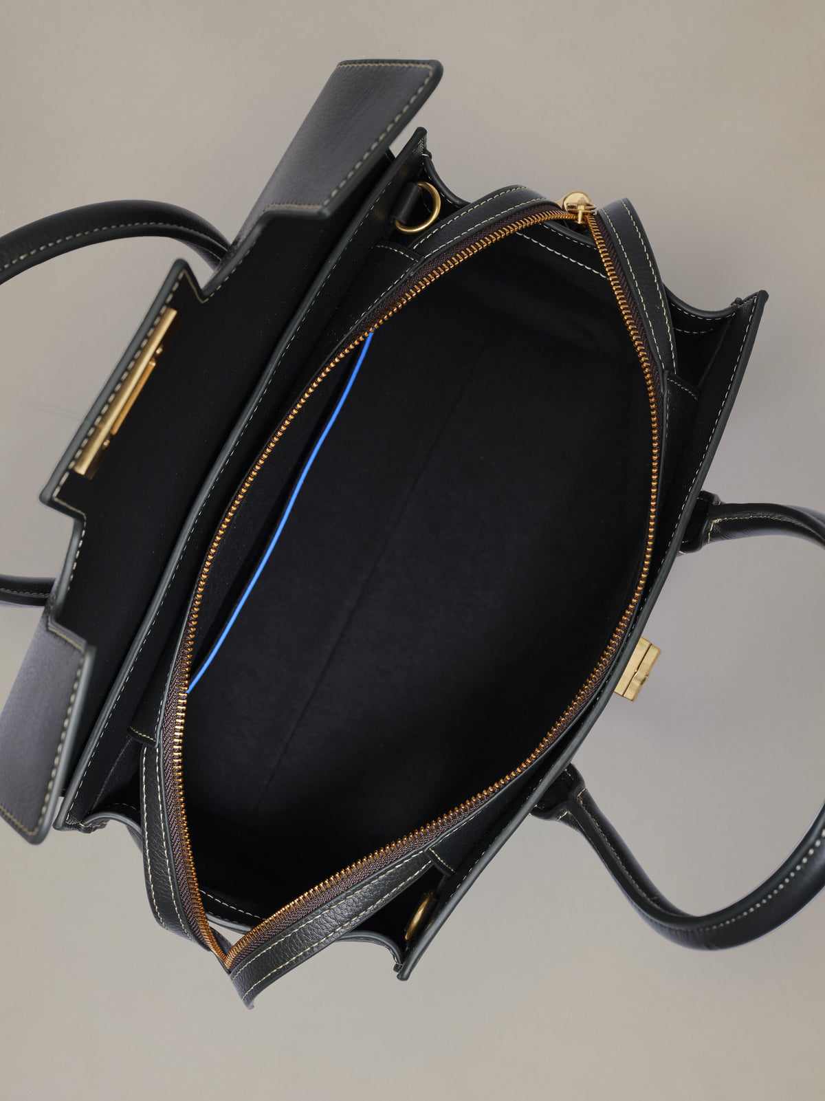 The Worth Leather Handbag by J.McLaughlin shown open with a spacious black interior and polished gold tone zipper detailing