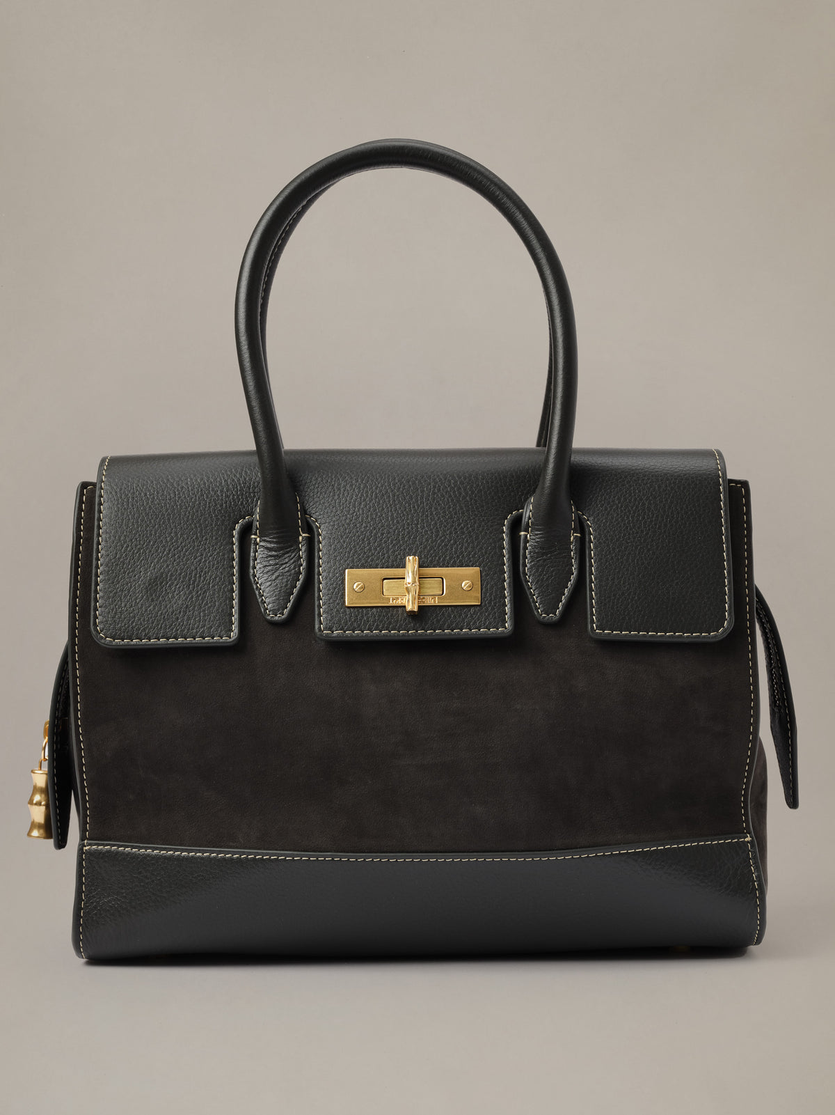 The Worth Leather Handbag by J.McLaughlin in black leather with structured top handles gold tone turnlock and front pockets