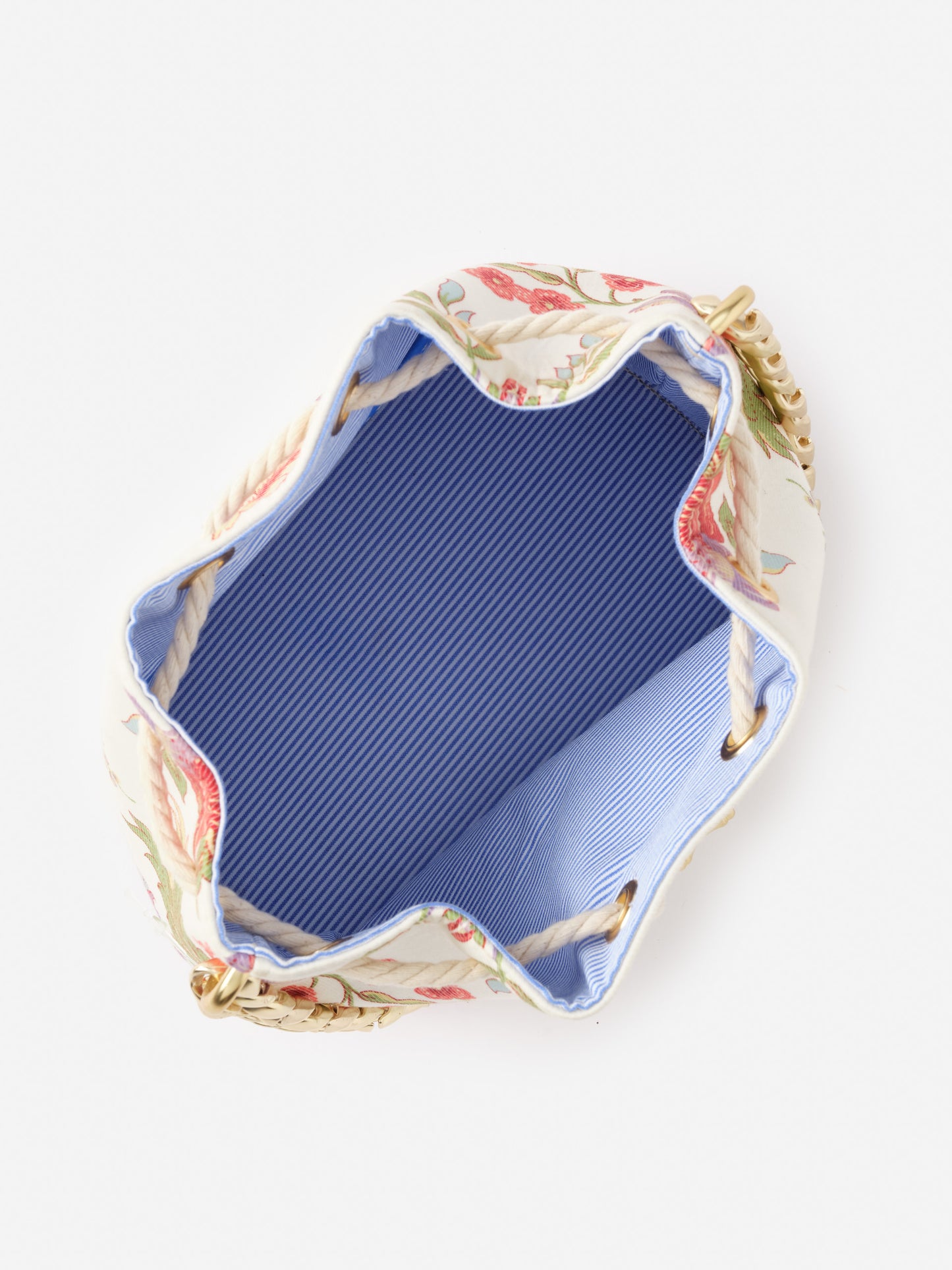 Top view of the open Daisy Bucket Bag in Mini Cerulean Garden by J.McLaughlin, showcasing its blue striped interior and floral exterior, embodying effortlessly stylish and enduring designs.