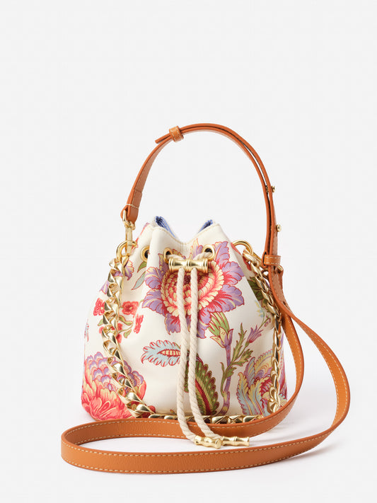 Daisy Bucket Bag in Mini Cerulean Garden by J.McLaughlin featuring a floral printed fabric with brown leather straps and gold chain accents, effortlessly stylish and designed for enduring style.