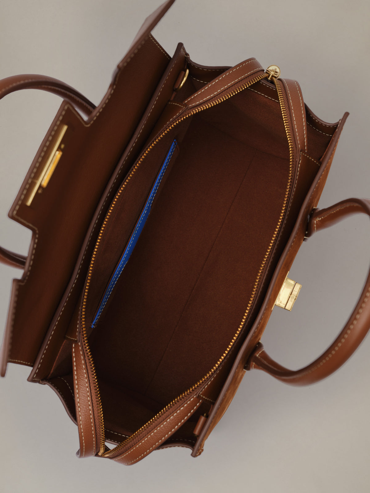 The Worth Leather Handbag by J.McLaughlin shown open with a spacious leather interior gold tone hardware and organized zip compartments