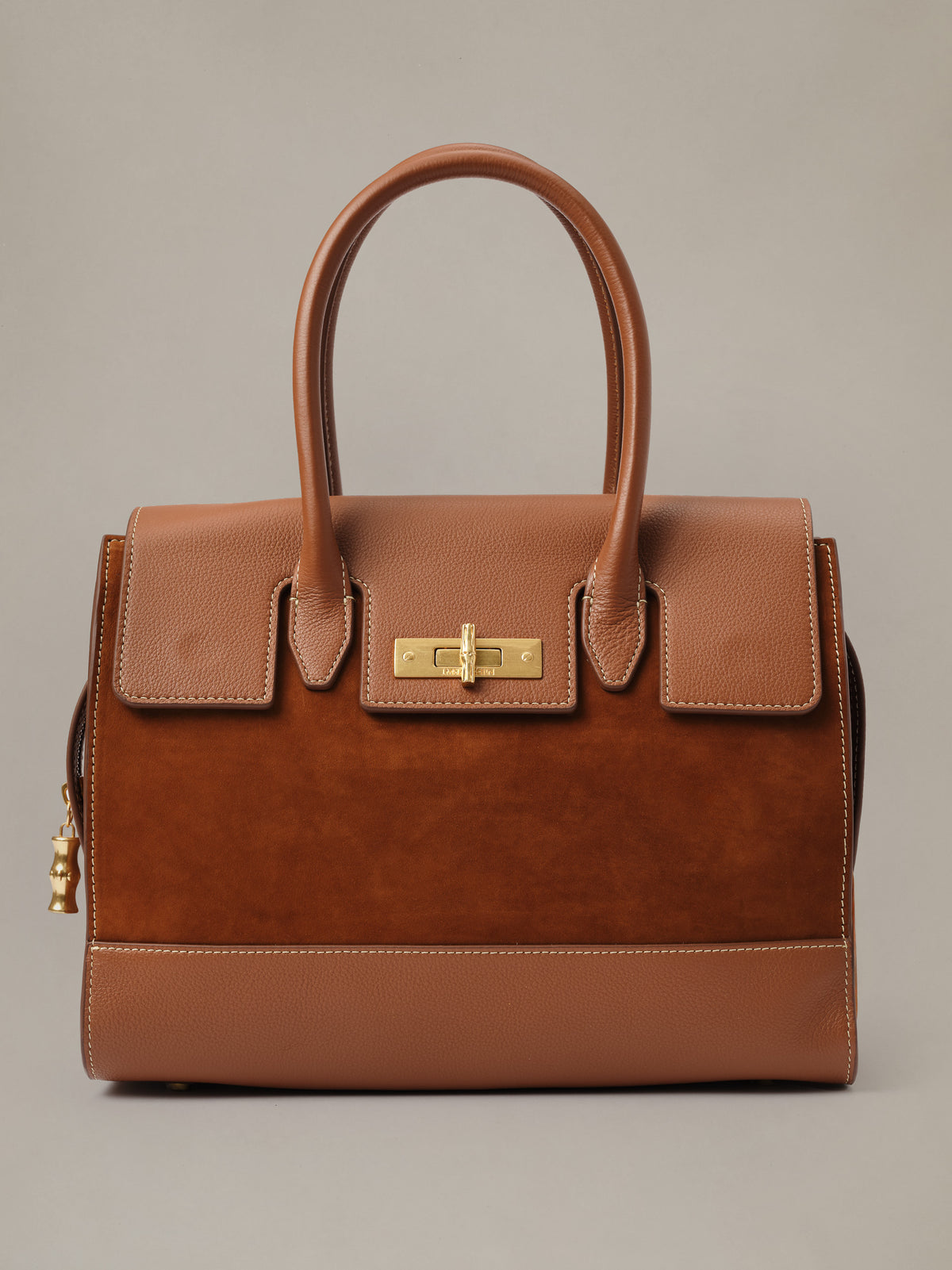The Worth Leather Handbag by J.McLaughlin in brown leather with structured top handles flap pockets and polished gold tone turnlock hardware