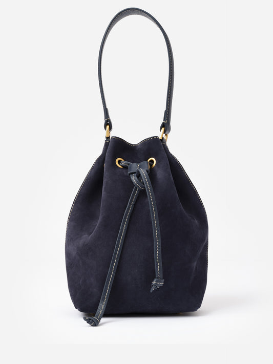 Newbury Suede Bucket Bag by J.McLaughlin in deep navy suede with drawstring closure and single shoulder strap, combining timeless style with effortless craftsmanship.