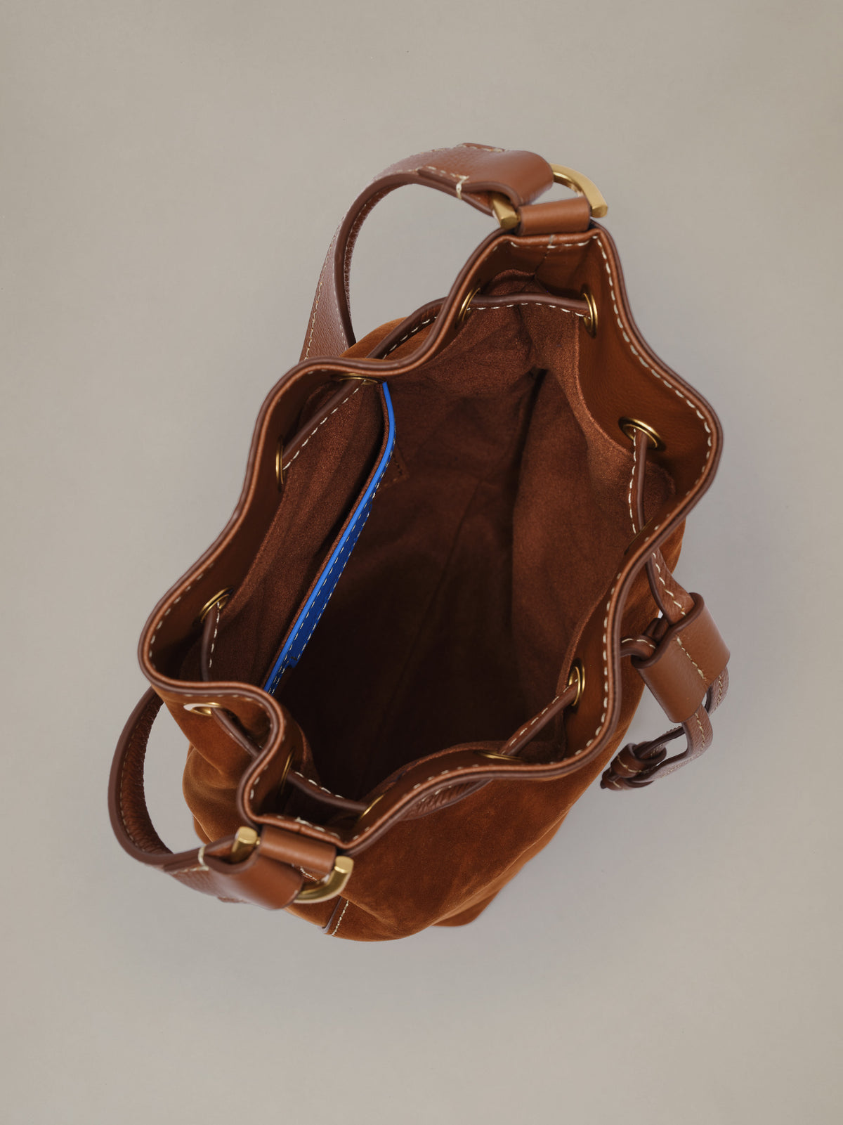 The Newbury Suede Bucket Bag by J.McLaughlin shown open from above in rich brown suede with a relaxed bucket shape and drawstring closure