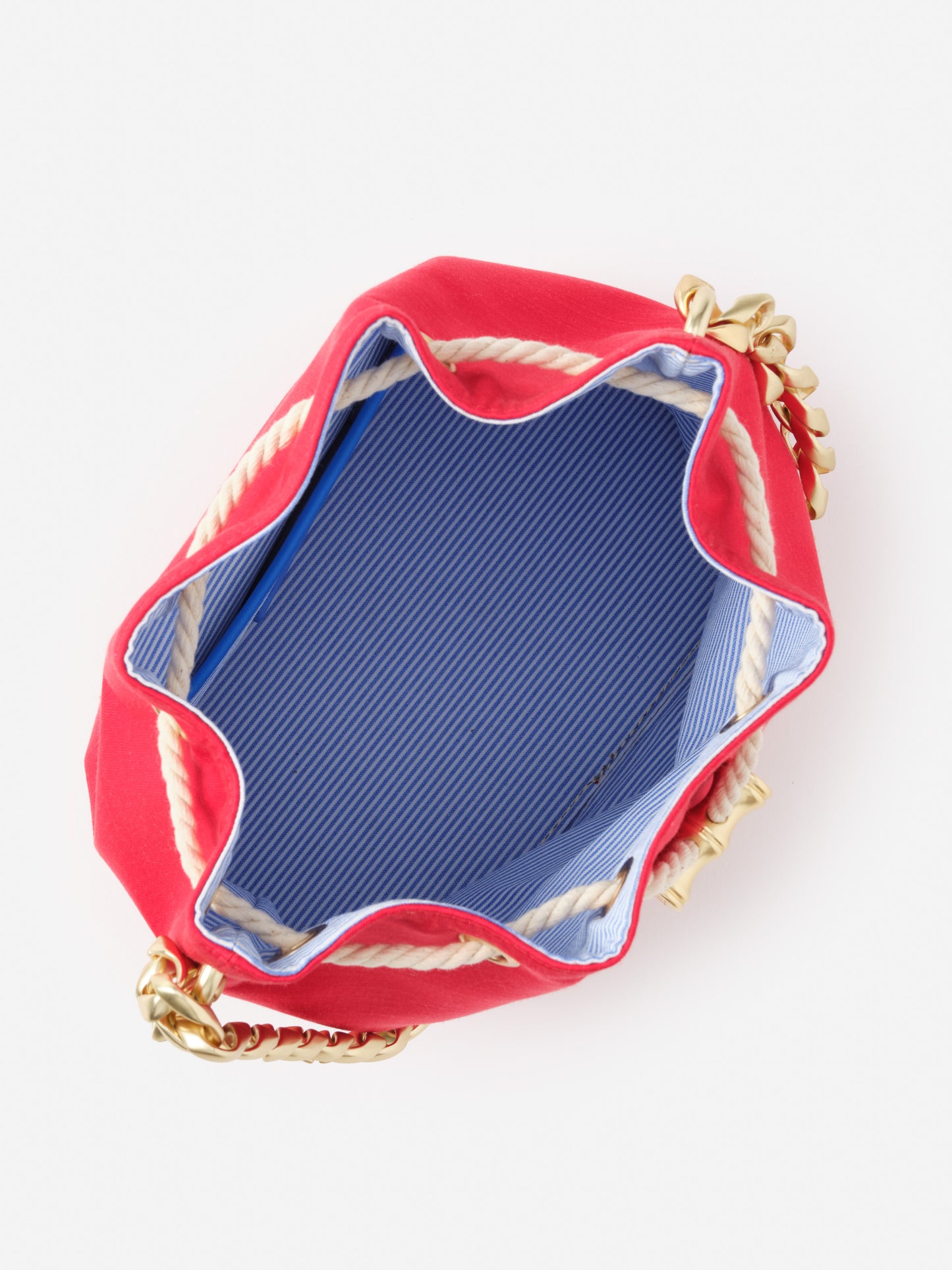 Interior view of the Sarah Bucket Bag by J.McLaughlin, showcasing a blue and white striped lining, gold chain strap, and rope trim, blending effortlessly stylish details with enduring designs.