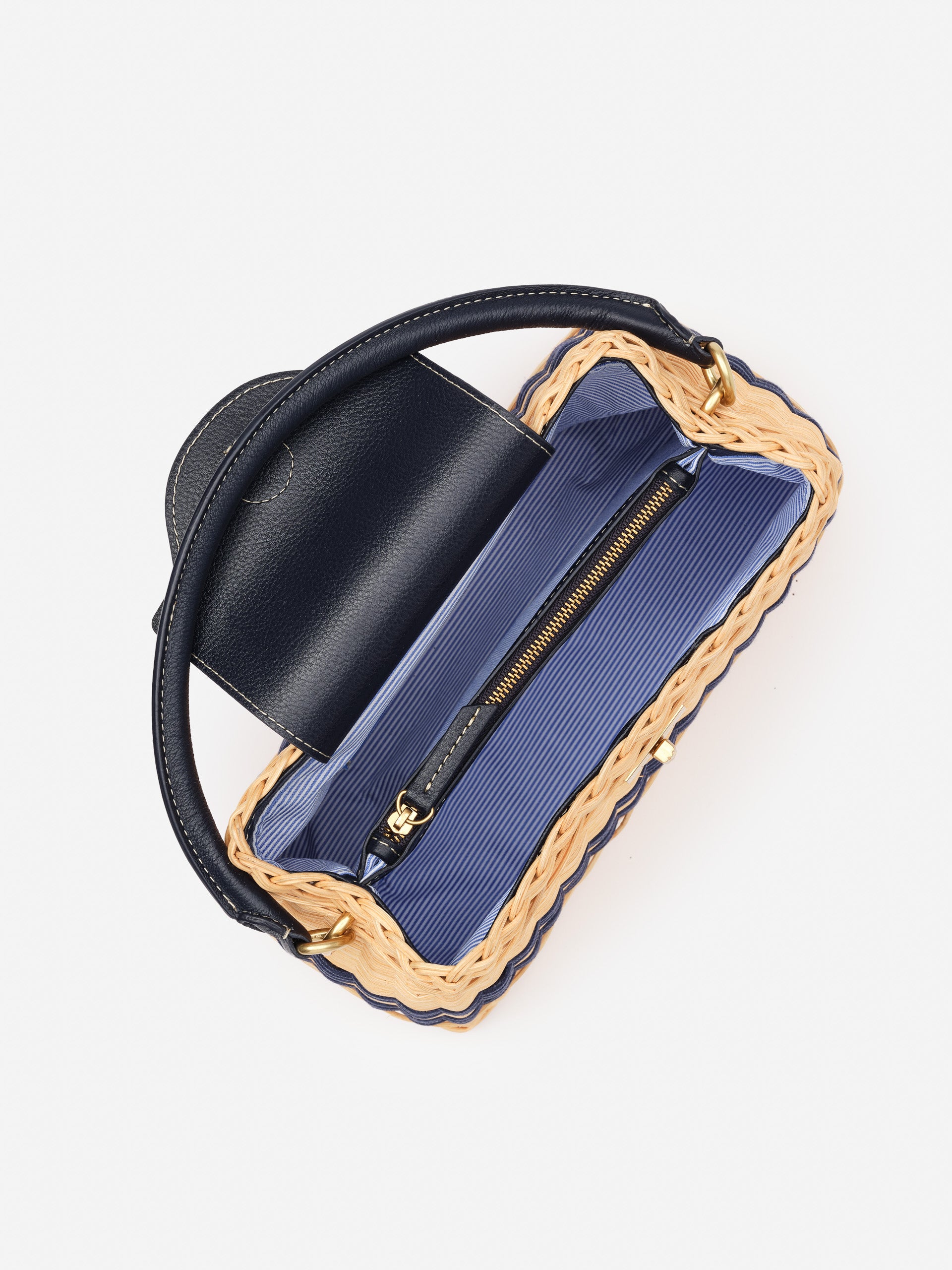 Open Faith Wicker Handbag by J.McLaughlin showing navy leather flap and handle, woven wicker frame, and striped fabric interior with zipper pocket, embodying effortlessly stylish, enduring designs from a destination for defining style. Life, Well-Lived.