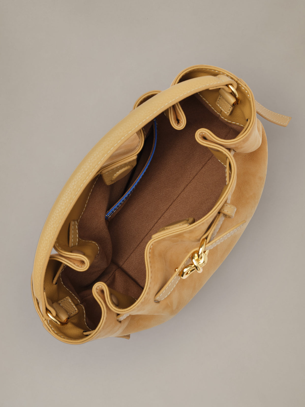 The Mini Lex Suede Handbag by J.McLaughlin in tan suede shown open with a spacious interior and adjustable crossbody strap