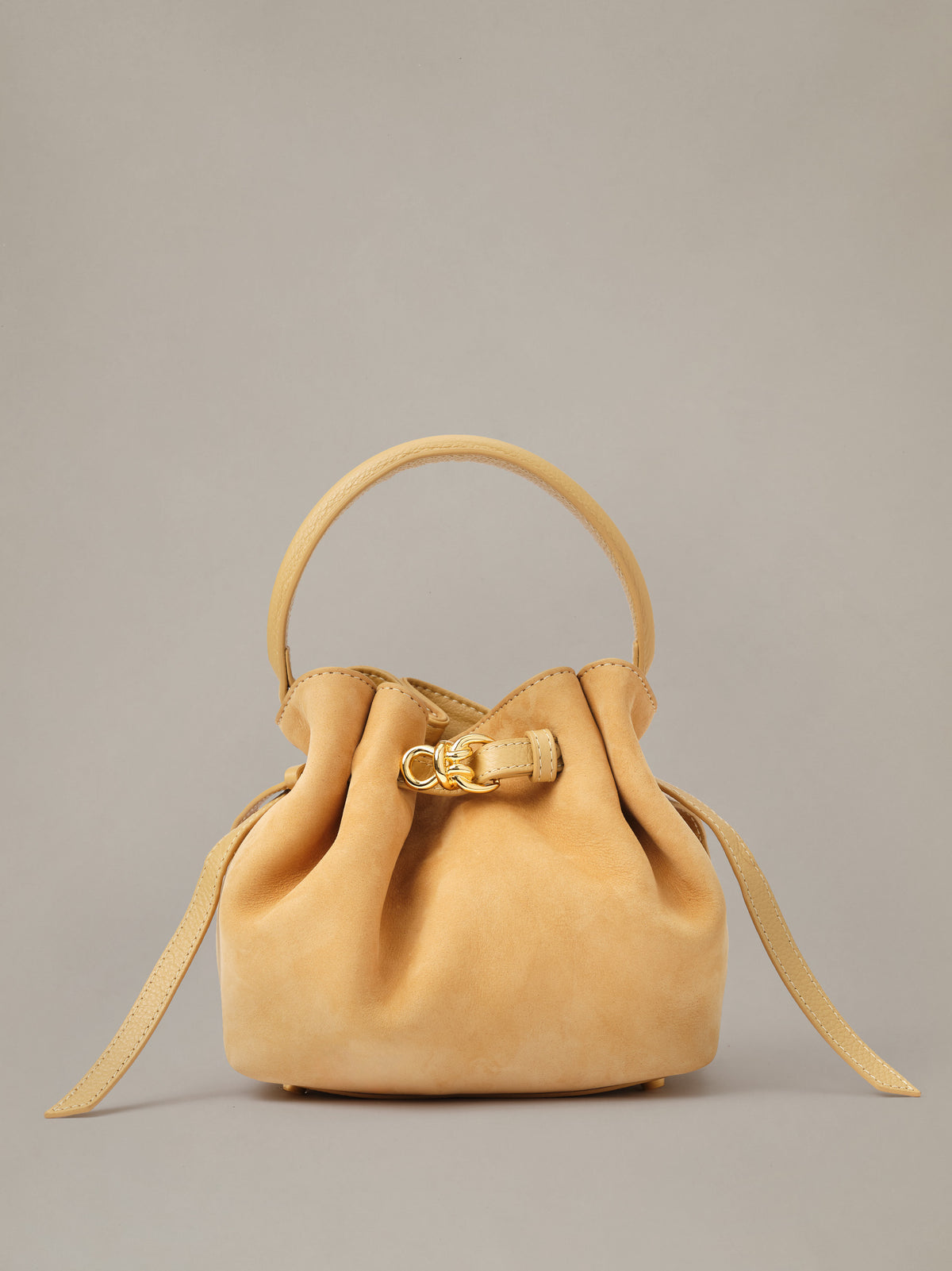 The Mini Lex Suede Handbag by J.McLaughlin in tan suede with a top handle drawstring closure and detachable crossbody strap for versatile everyday style