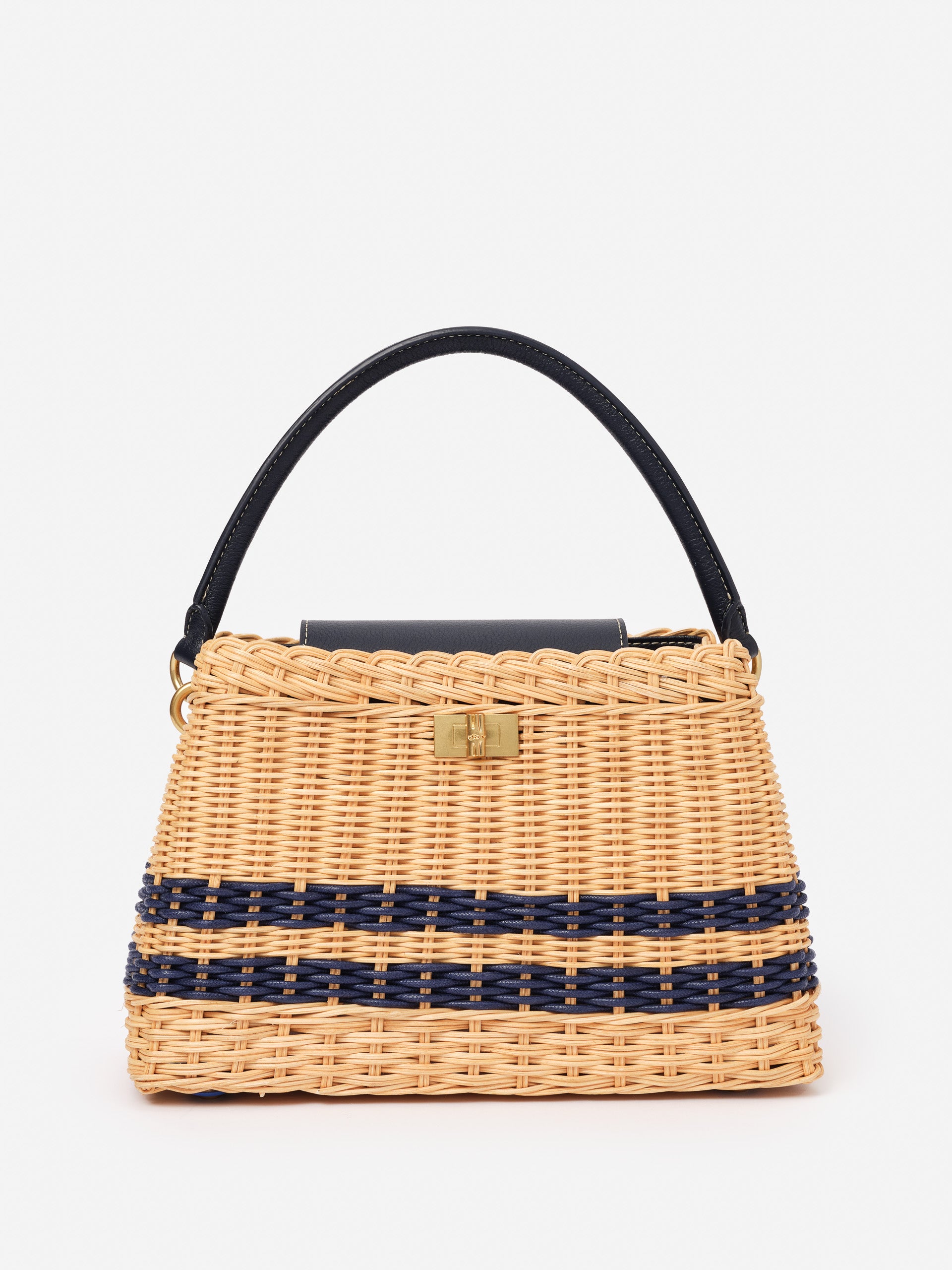 Faith Wicker Handbag by J.McLaughlin, crafted with wicker and navy detailing, offers an effortlessly stylish accessory that embodies enduring designs and timeless fashion.
