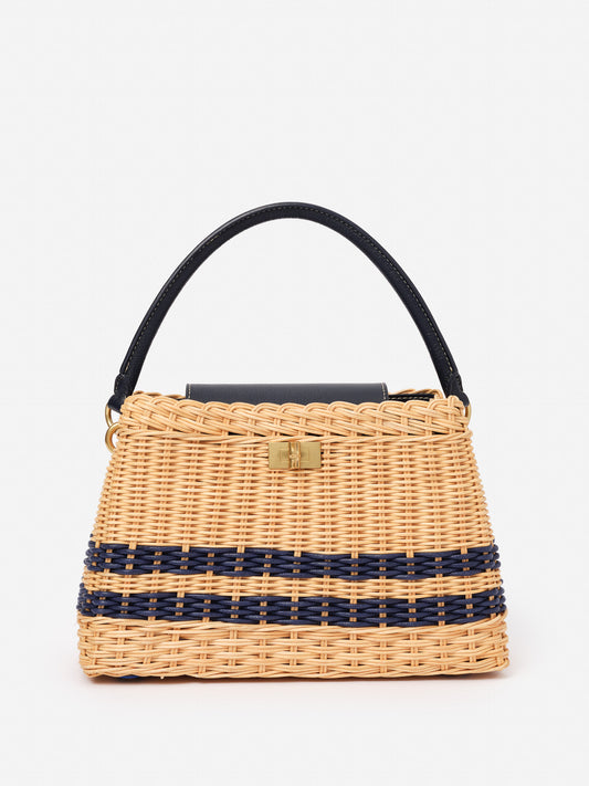 Faith Wicker Handbag by J.McLaughlin, crafted with wicker and navy detailing, offers an effortlessly stylish accessory that embodies enduring designs and timeless fashion.