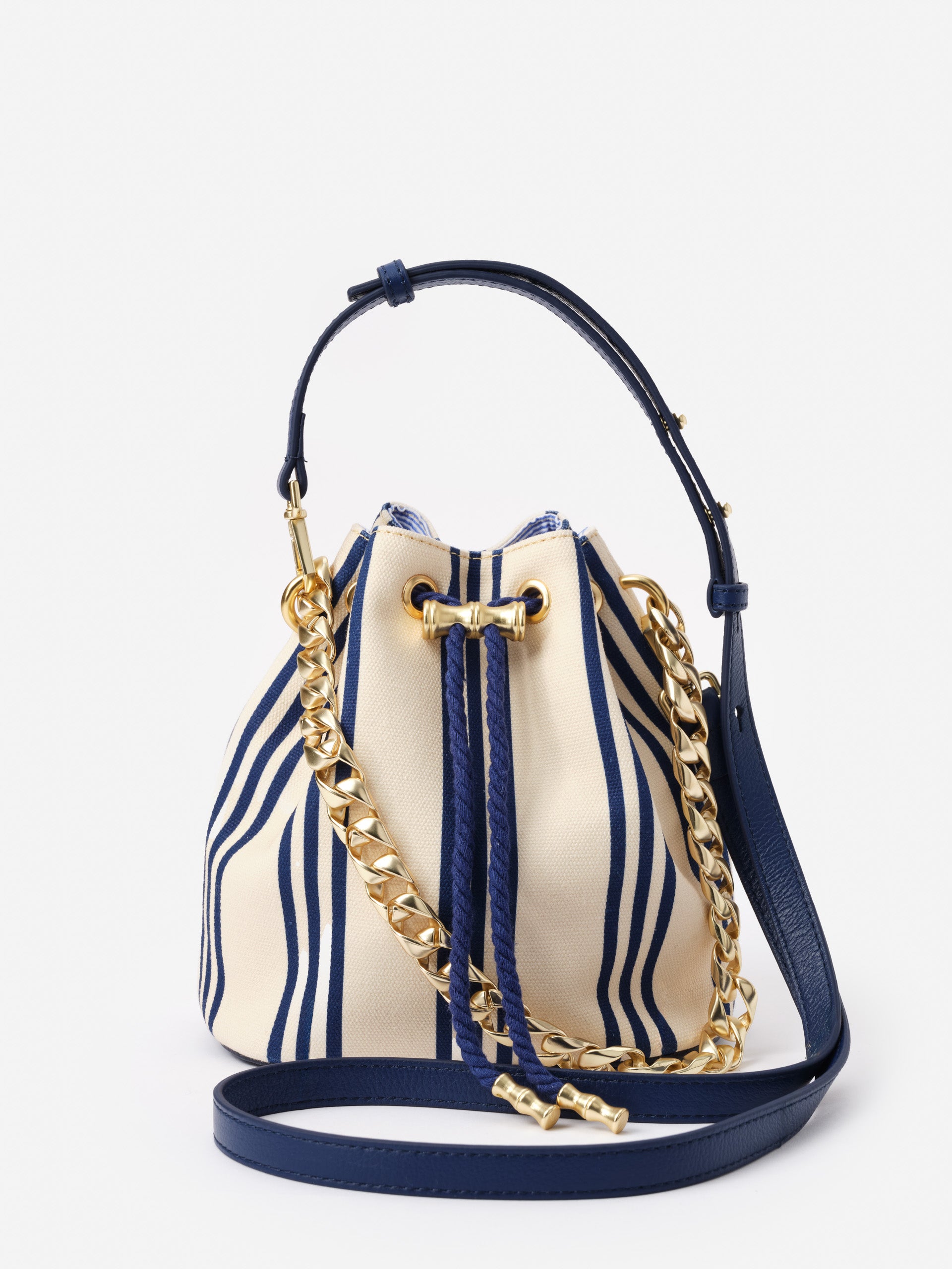 Daisy Canvas Bucket Bag in Stripe by J.McLaughlin featuring a classic navy and cream striped pattern with a gold chain and leather strap, showcasing effortlessly stylish, enduring designs.