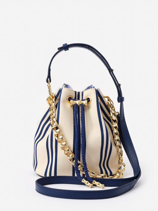 Daisy Canvas Bucket Bag in Stripe by J.McLaughlin featuring a classic navy and cream striped pattern with a gold chain and leather strap, showcasing effortlessly stylish, enduring designs.