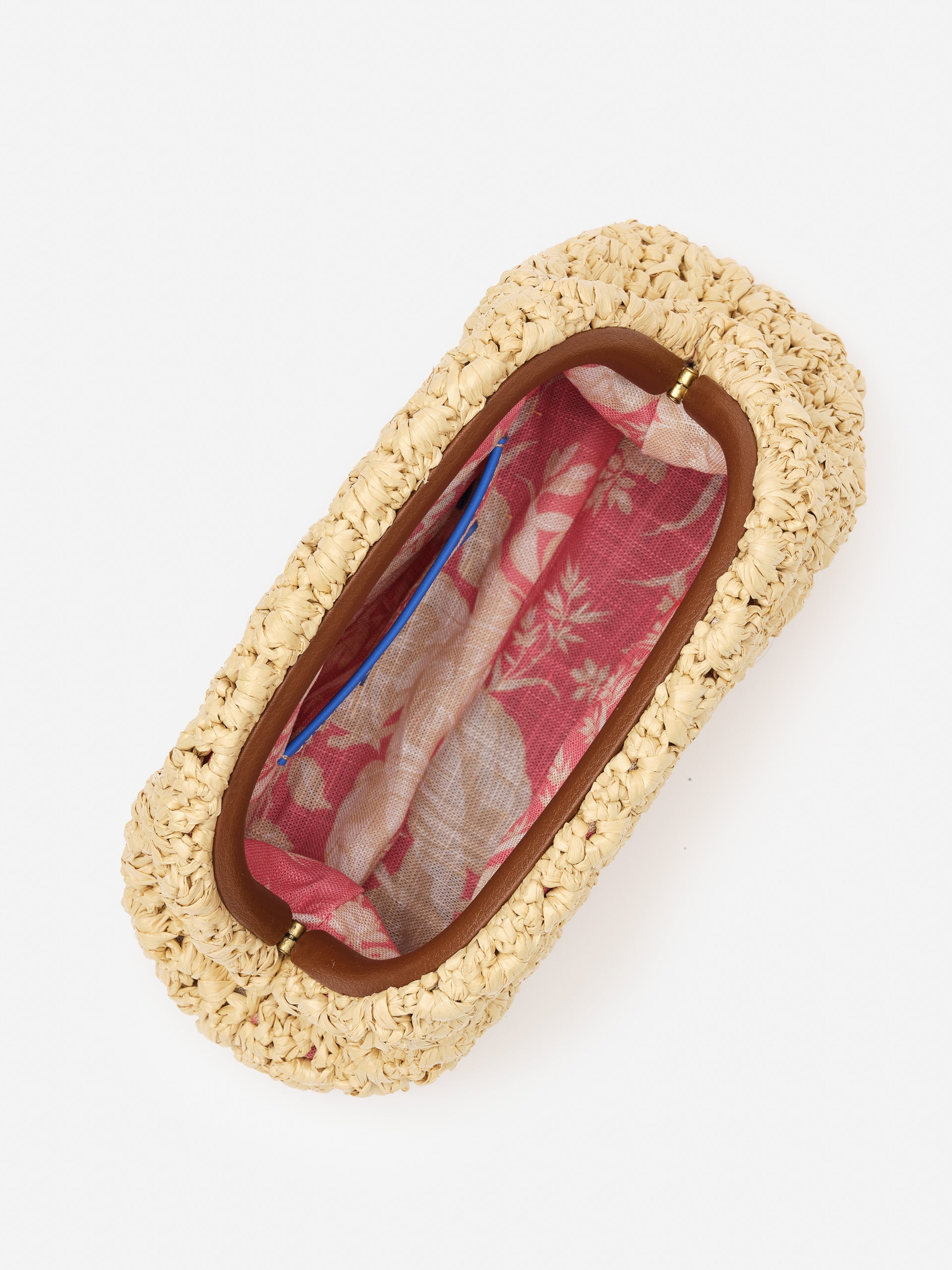 Top view of the Bambi Hand Crochet Clutch by J.McLaughlin, showcasing its cream crochet exterior and vibrant pink floral fabric interior, effortlessly stylish and enduring design.
