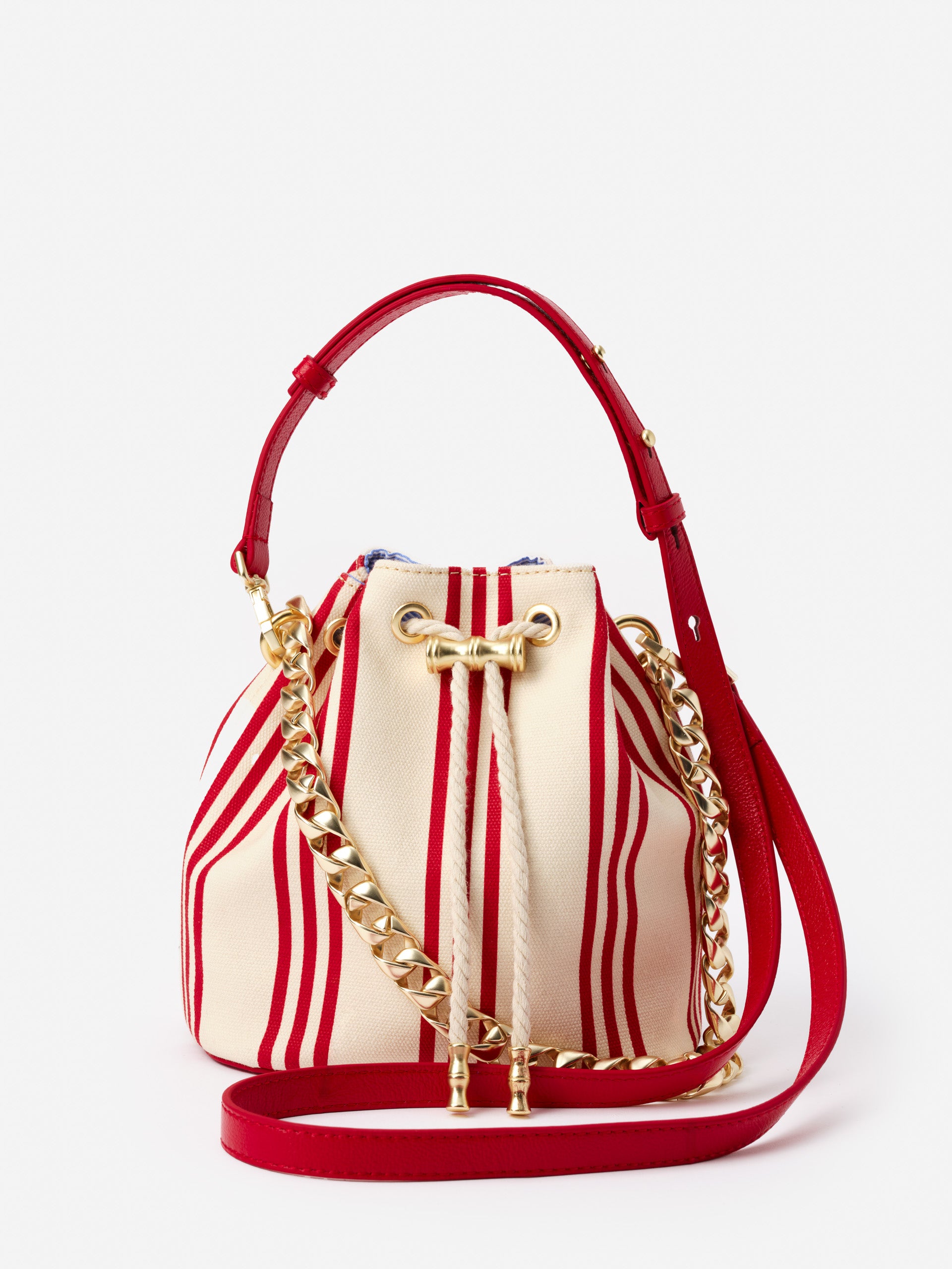 Daisy Canvas Bucket Bag in Stripe by J.McLaughlin featuring red and cream stripes, gold chain detail, and a red adjustable strap, showcasing effortlessly stylish, enduring designs for life well-lived.