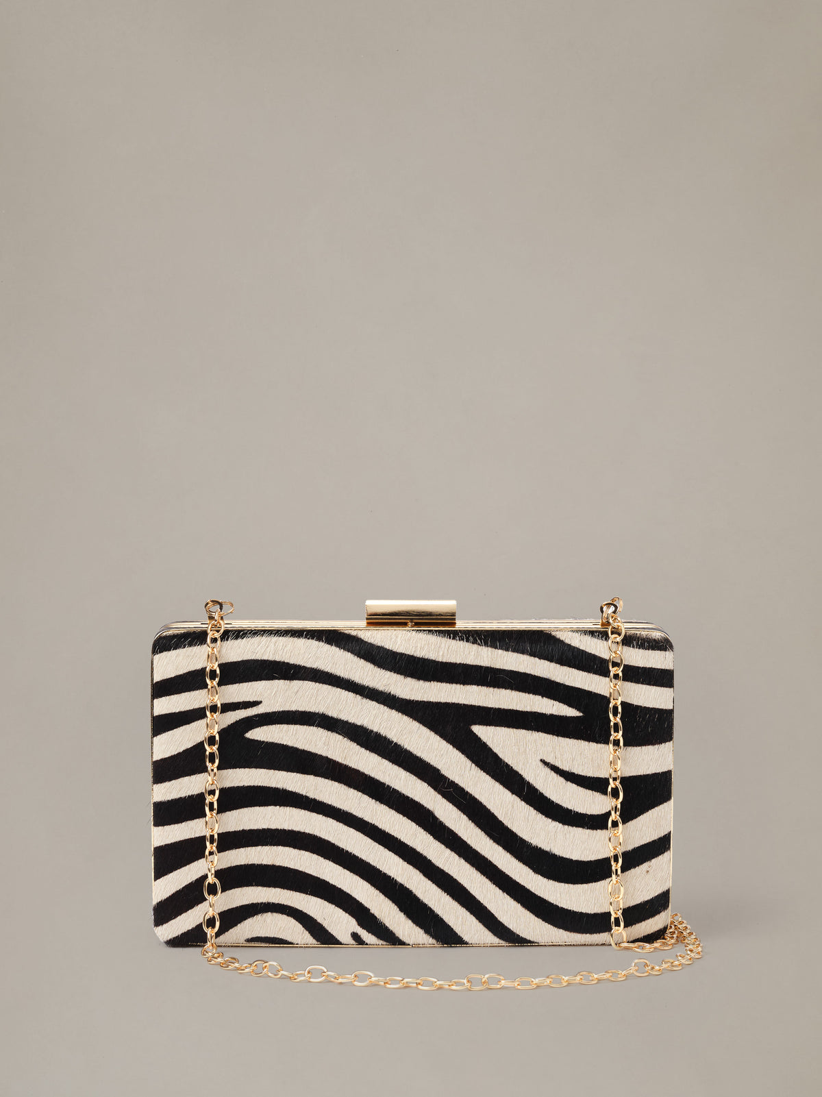 The Palm Pony Hair Clutch in Zebra Stripes by J.McLaughlin featuring bold black and ivory zebra stripes with a gold tone chain for elegant evening style