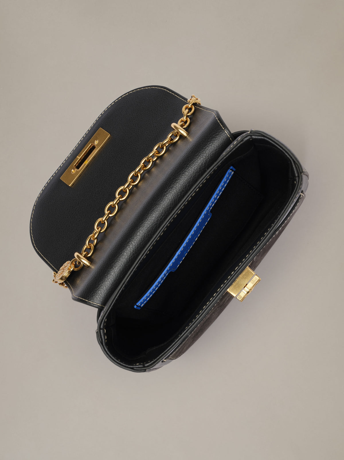 The Waverly Leather Handbag by J.McLaughlin open to show a black leather interior gold chain strap and organized compartments