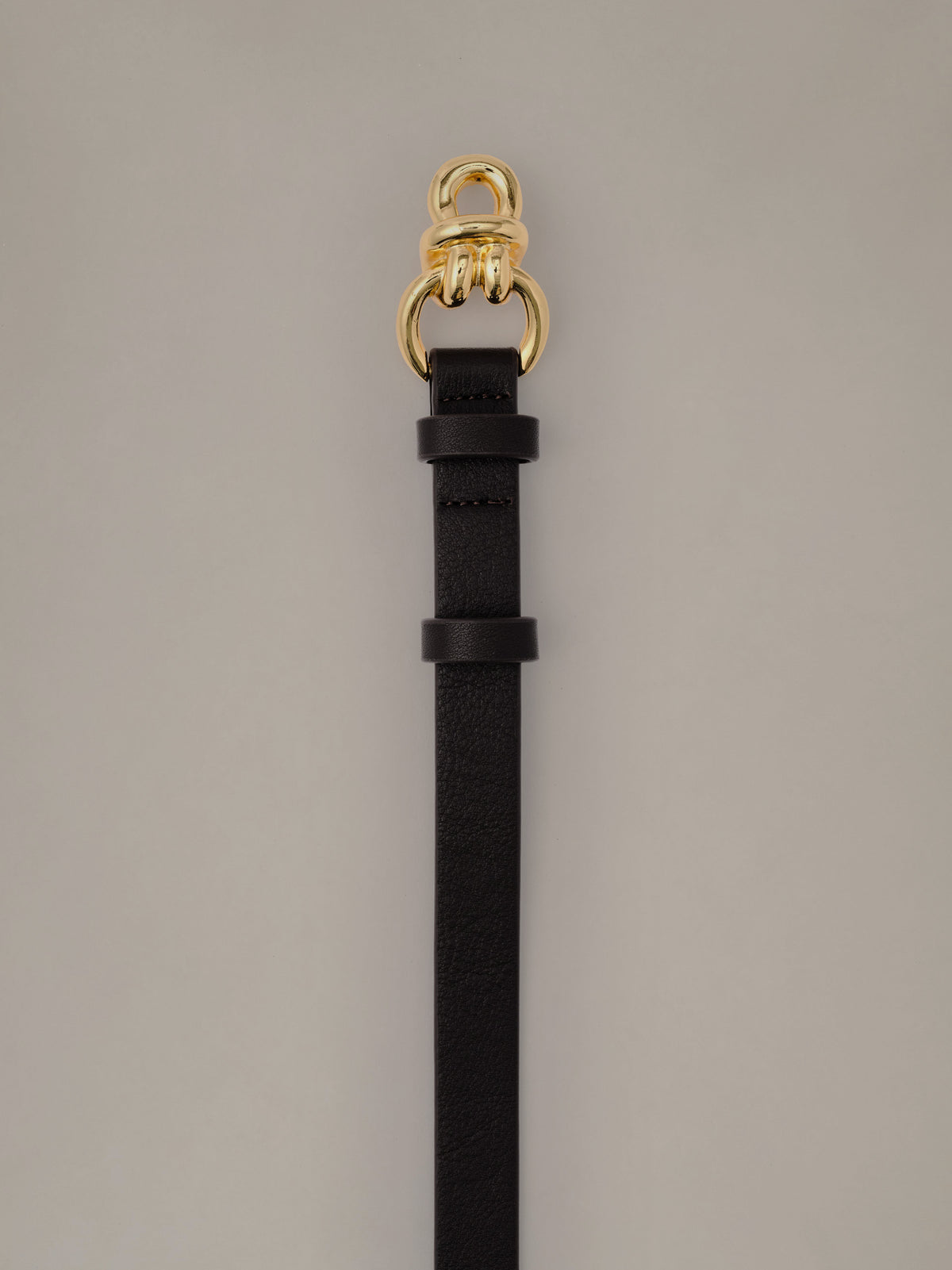 Natalie Leather Belt by J.McLaughlin in black leather with a slim profile and signature gold knot hardware