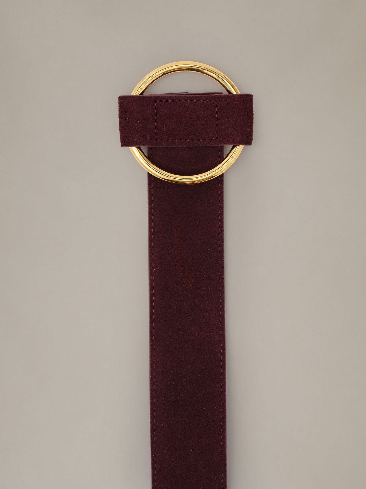 Amelia Suede Belt by J.McLaughlin in burgundy suede with a polished gold ring buckle shown against a neutral background
