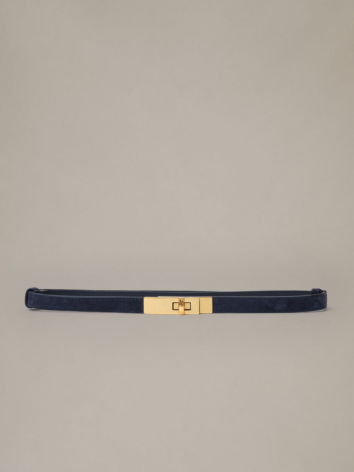 Liv Suede Belt by J.McLaughlin in soft dark suede with a polished gold turn lock buckle shown against a neutral background