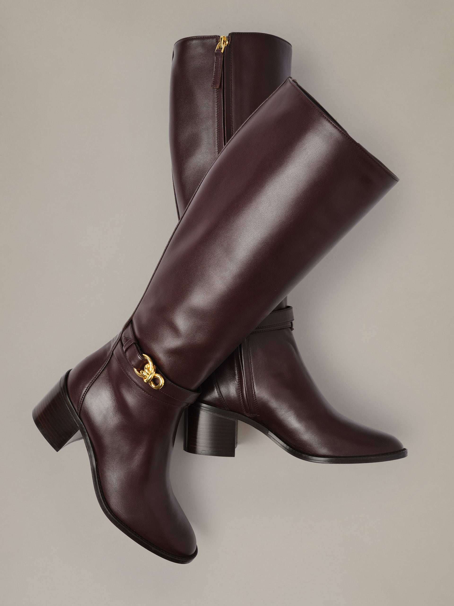 Addison Leather Boots by J.McLaughlin in rich burgundy leather with knee-high shafts stacked block heels and signature gold bamboo zipper pulls