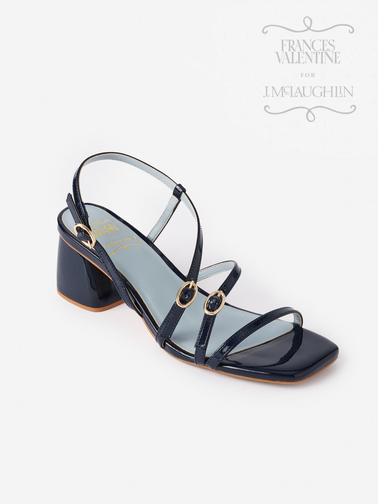 Lexi Heels by J.McLaughlin feature effortlessly stylish navy straps with gold buckles and a block heel, showcasing enduring designs and innovative fabrics for timeless fashion.