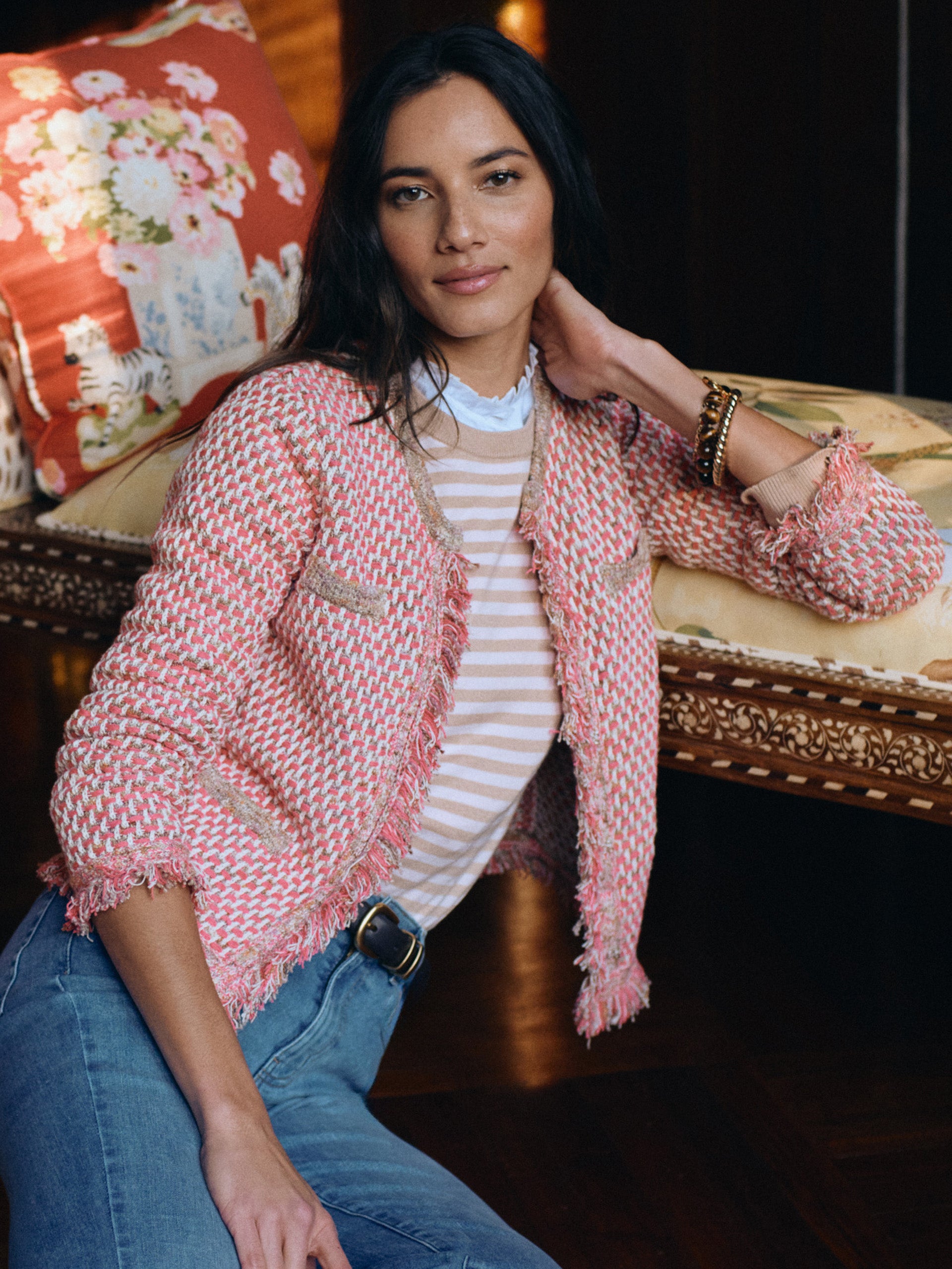 A woman wearing a pink and beige woven Marceline Cardigan by J.McLaughlin, paired with a striped top and jeans, showcasing effortlessly stylish, enduring designs in innovative fabrics from a destination for defining style. Life, Well-Lived.